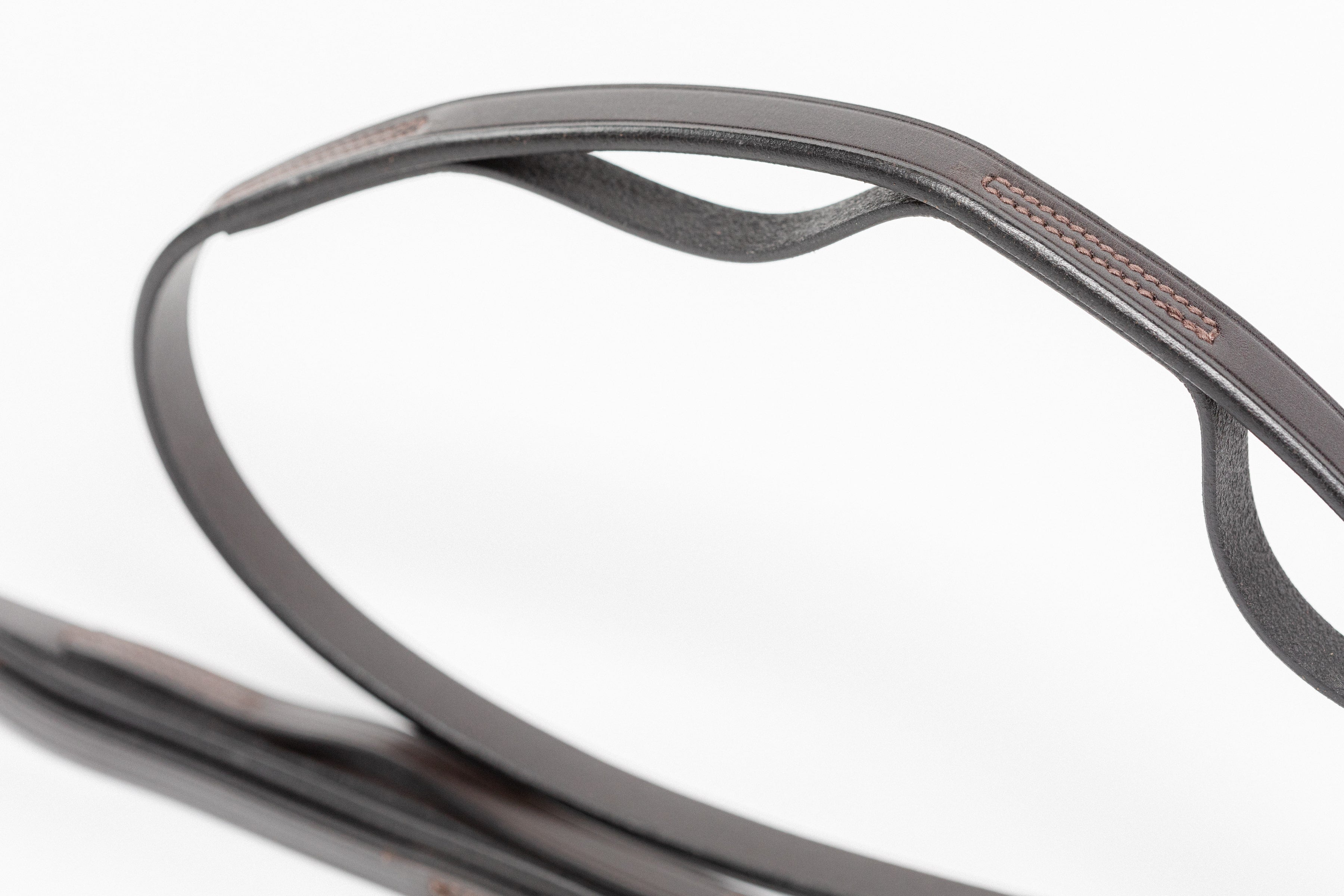 Detail of high-quality 5/8" leather reins with strategically placed finger grips, highlighting the craftsmanship with close-up view of the stitching and rolled leather construction.