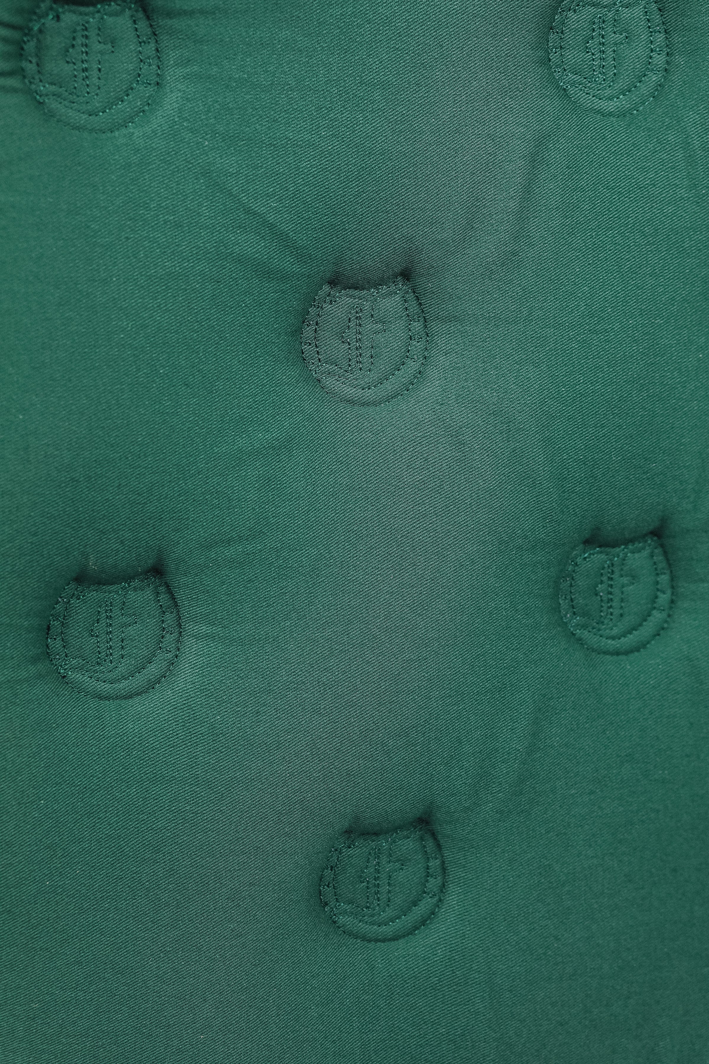 Detailed view of the Freedman’s logo patterned quilting on a green saddle pad.