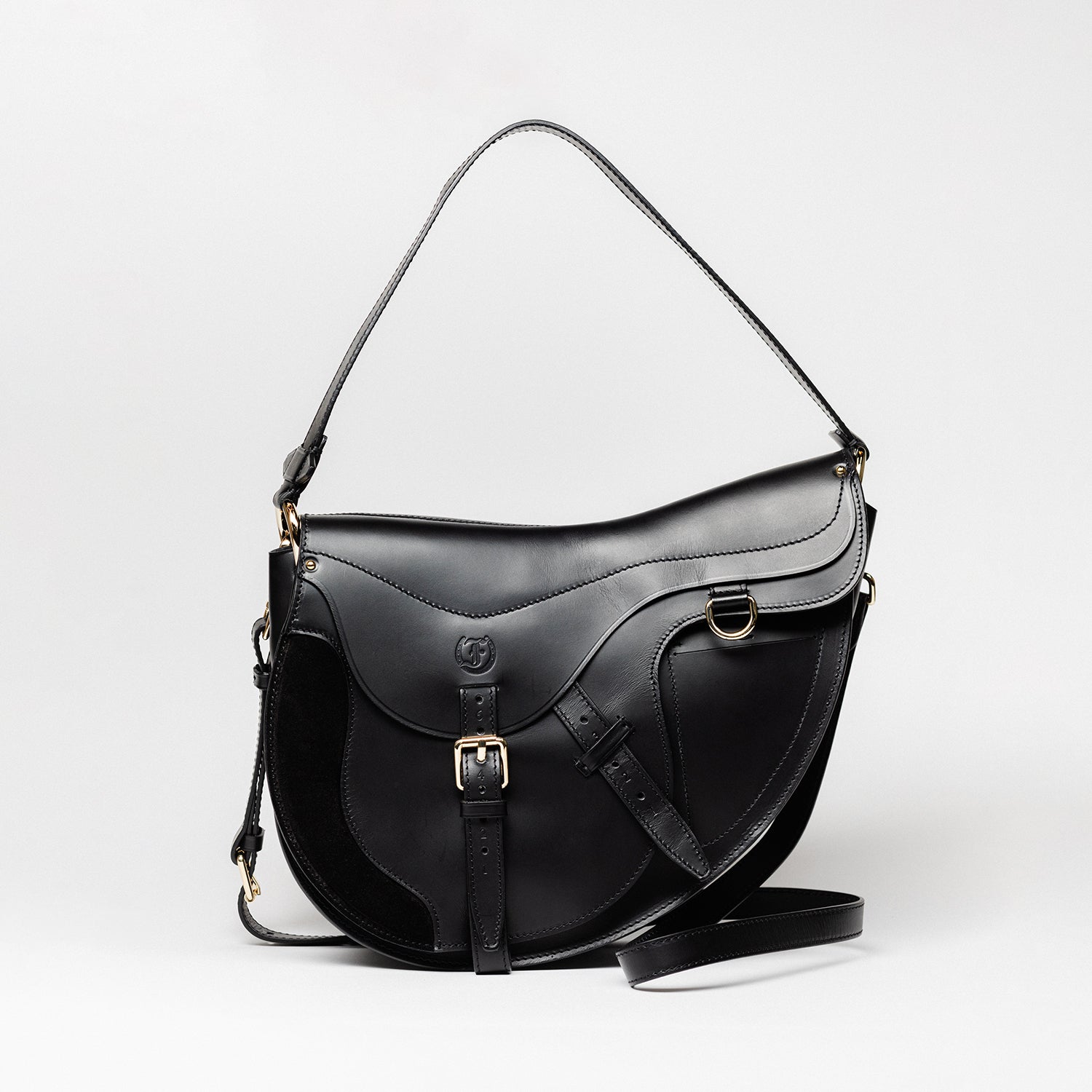Freedman’s Burghley Shoulder Bag in black leather, featuring gold finished hardware, a distinctive saddle-inspired silhouette, and an adjustable shoulder strap, on a white background.