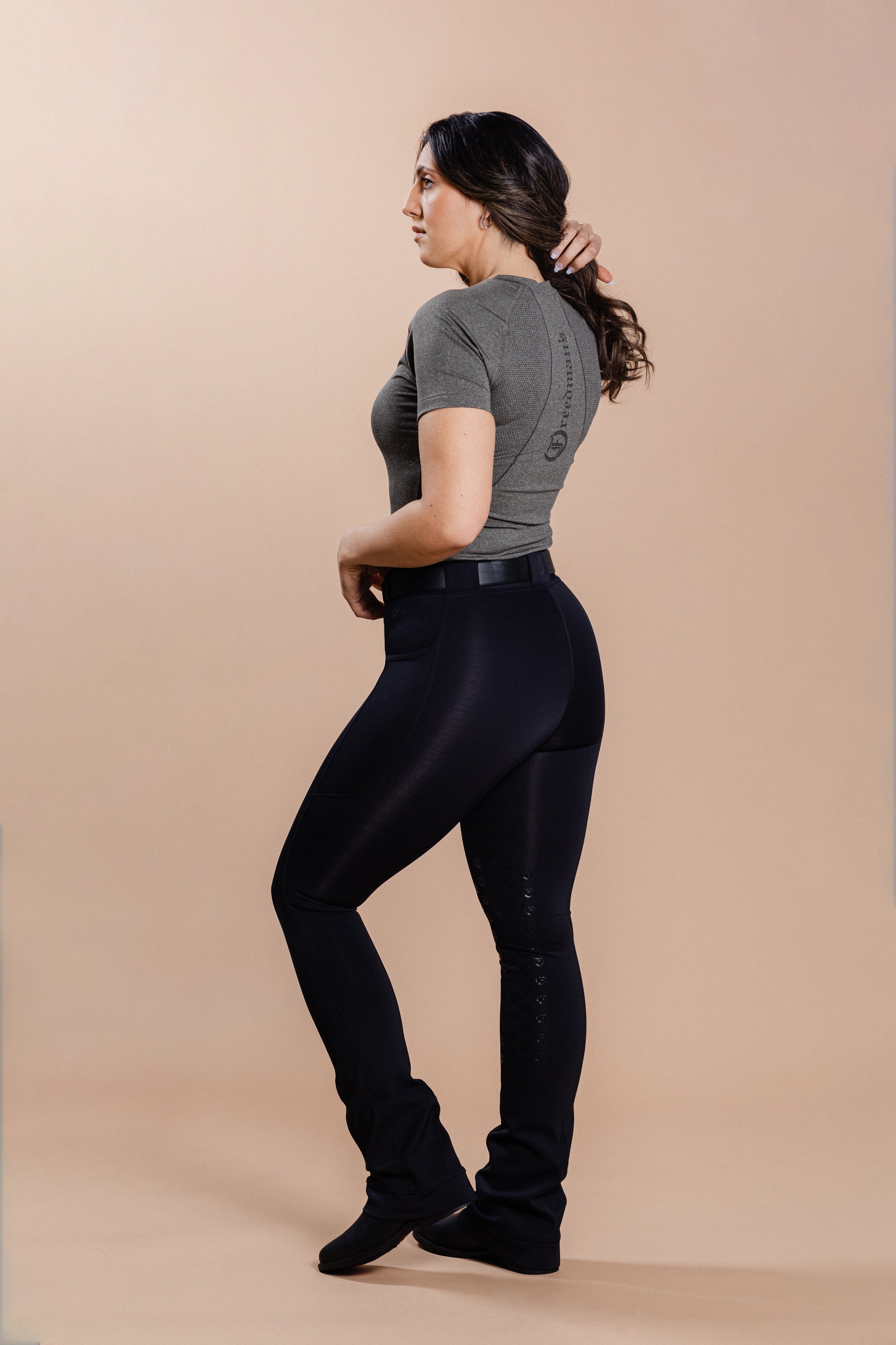 Freedman's Ladies' Tous les Jours Essential V Neck Tee Shirt in ash grey, back view featuring a V-neckline, short sleeves, a "Freedman's" print, and styled with black jods.