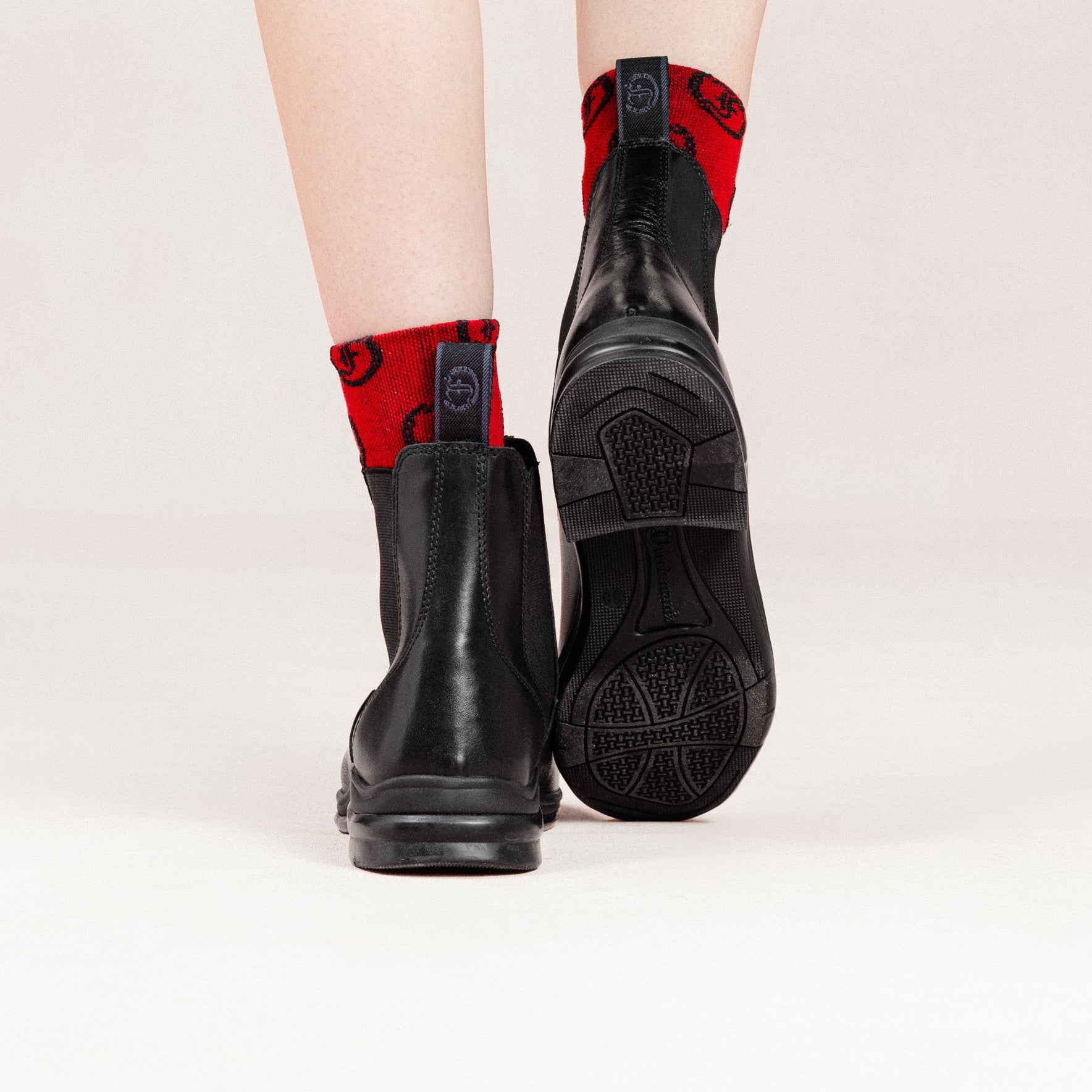 Freedman's Pisgah Jodhpur Boot, black leather, back view with red patterned socks, highlighting the boot's sole and heel details.