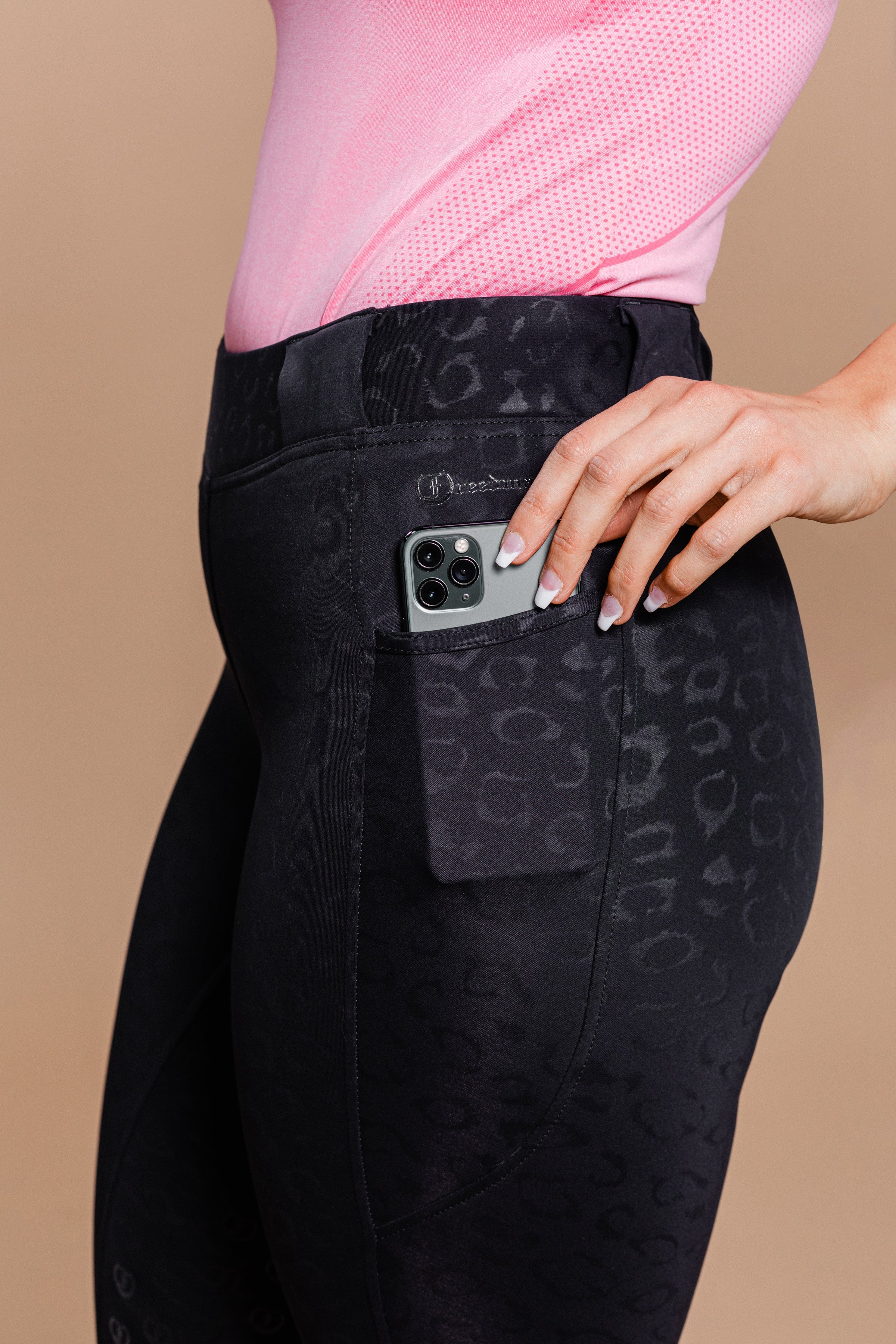 Stylish Tous les Jours Jods - Black Cheetah  by Freedman's – sleek, comfortable, and perfect for equestrian fashion. Close up of pocket with Freeman's name print and phone.