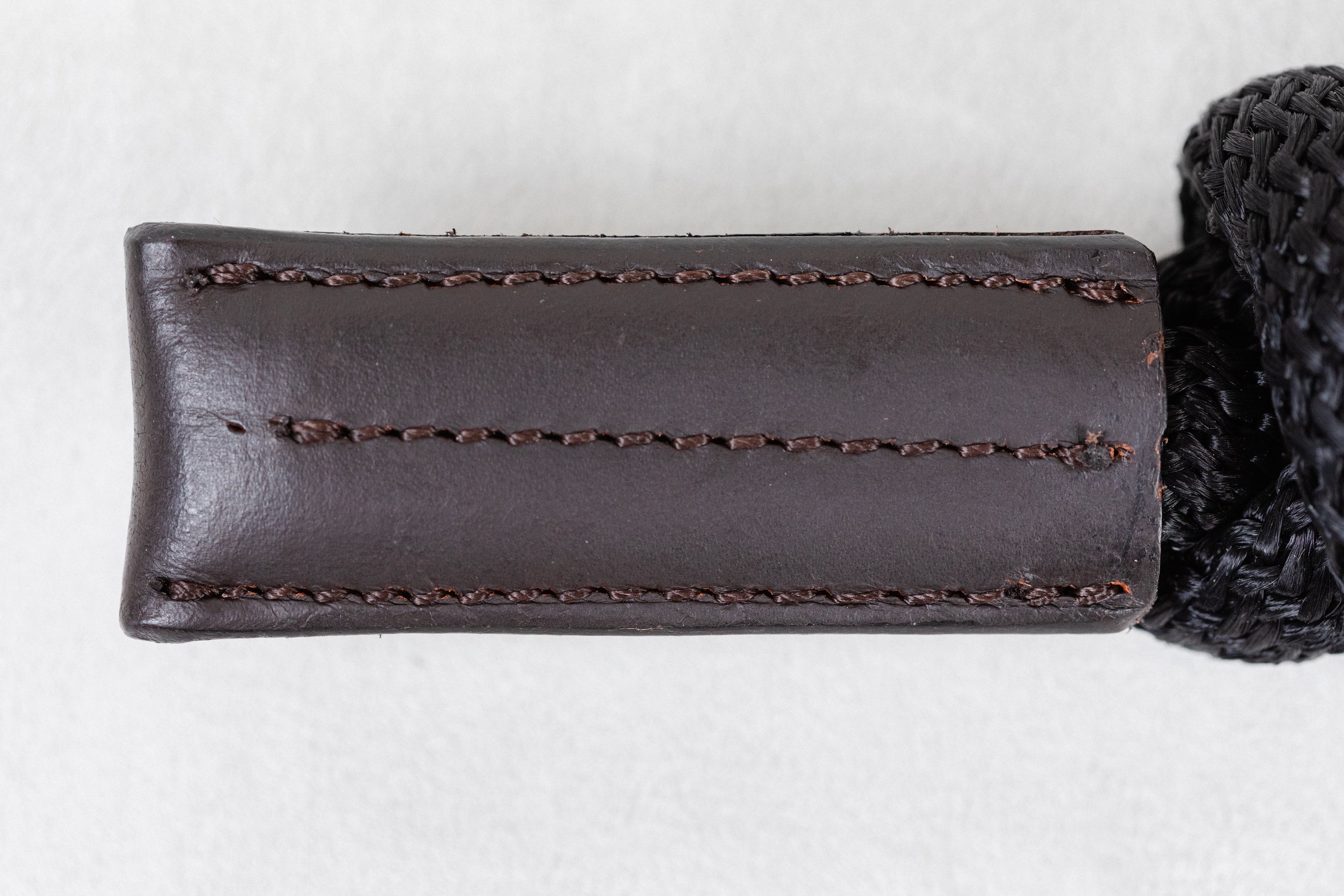 Brown leather case with stitching detail on a white background