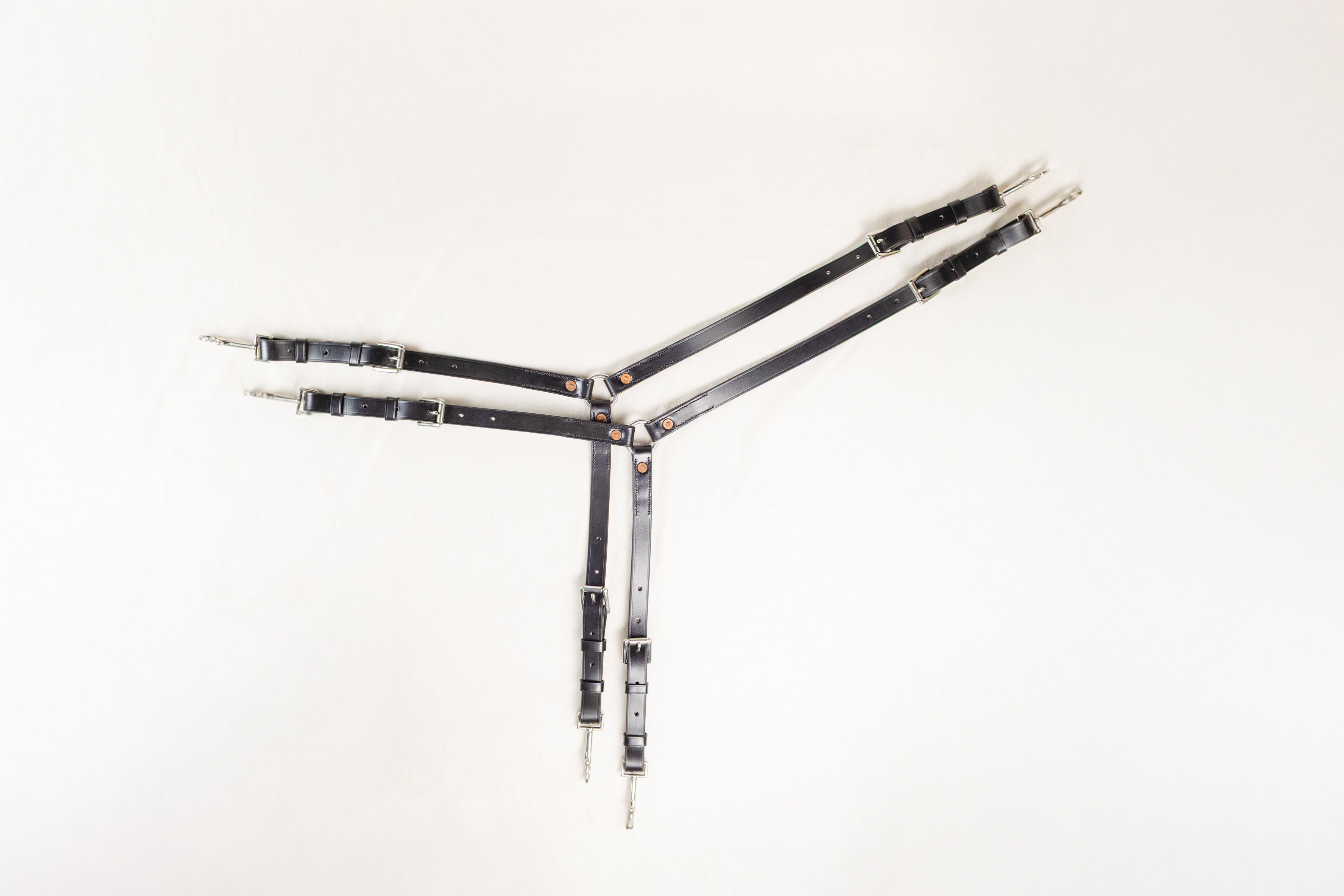A set of black 'Y' straps with stainless steel buckles, rings, and snap clips, designed for pony crupper and bustle sets.