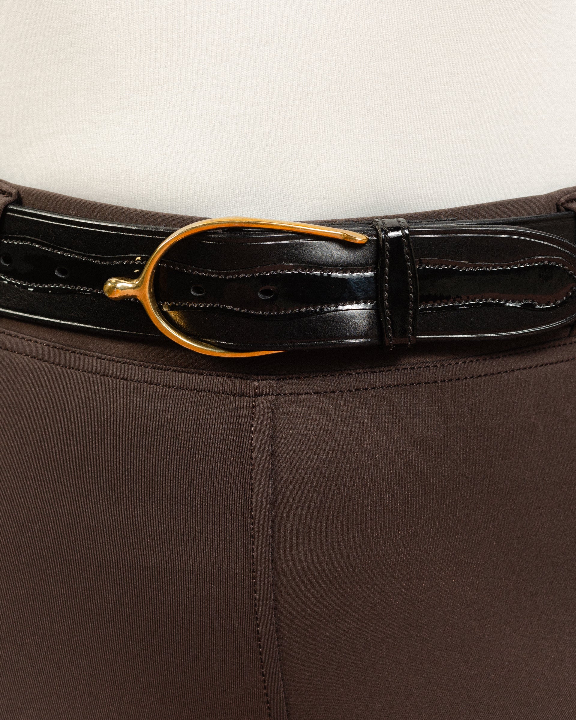 After Dark Brown Jod with the Patent Scalloped Spur Belt featuring a brass buckle on a white background, made by Freedman’s Harness.