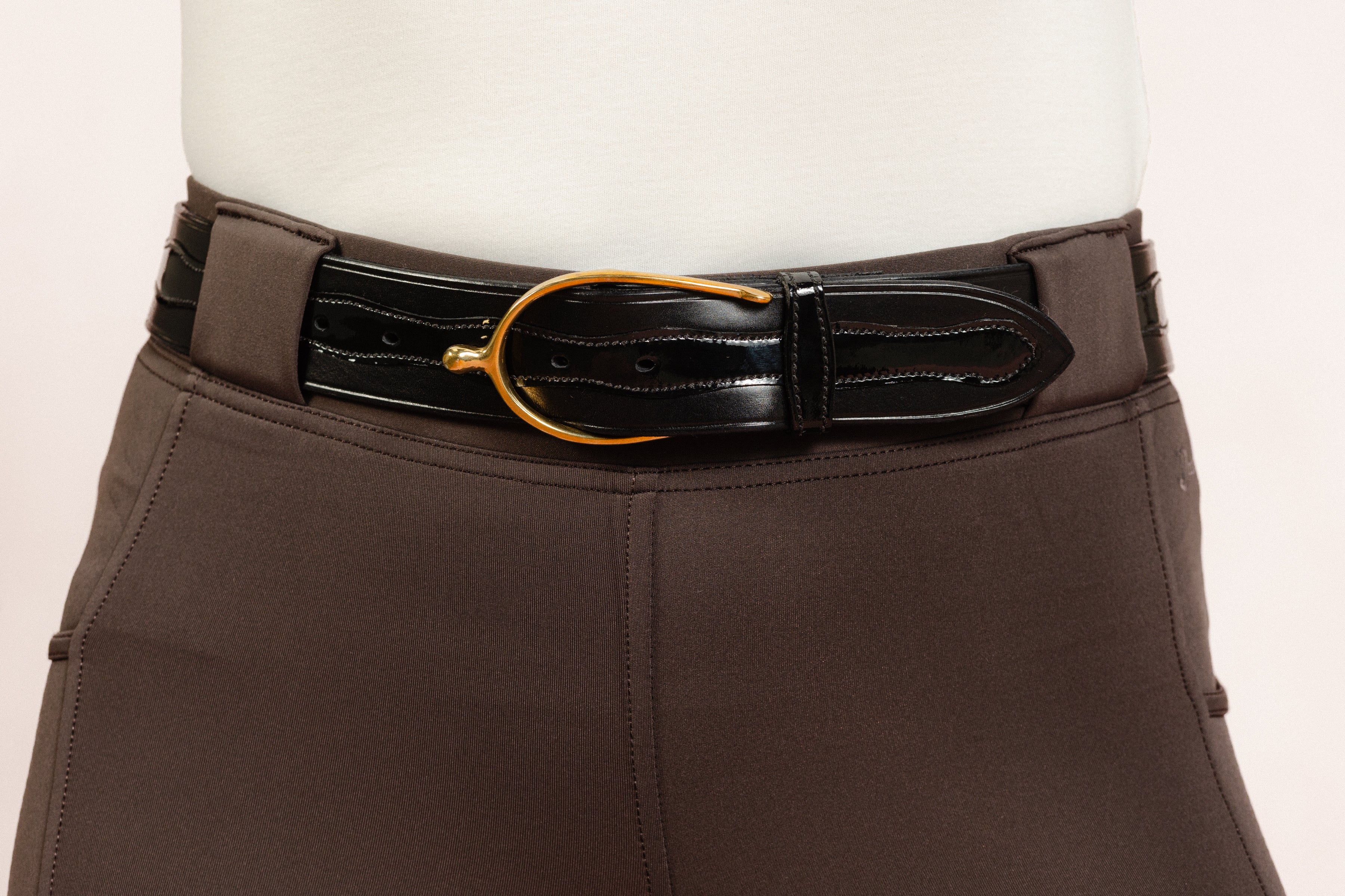 After Dark Brown Jod with the Patent Scalloped Spur Belt featuring a brass buckle on a white background, made by Freedman’s Harness.