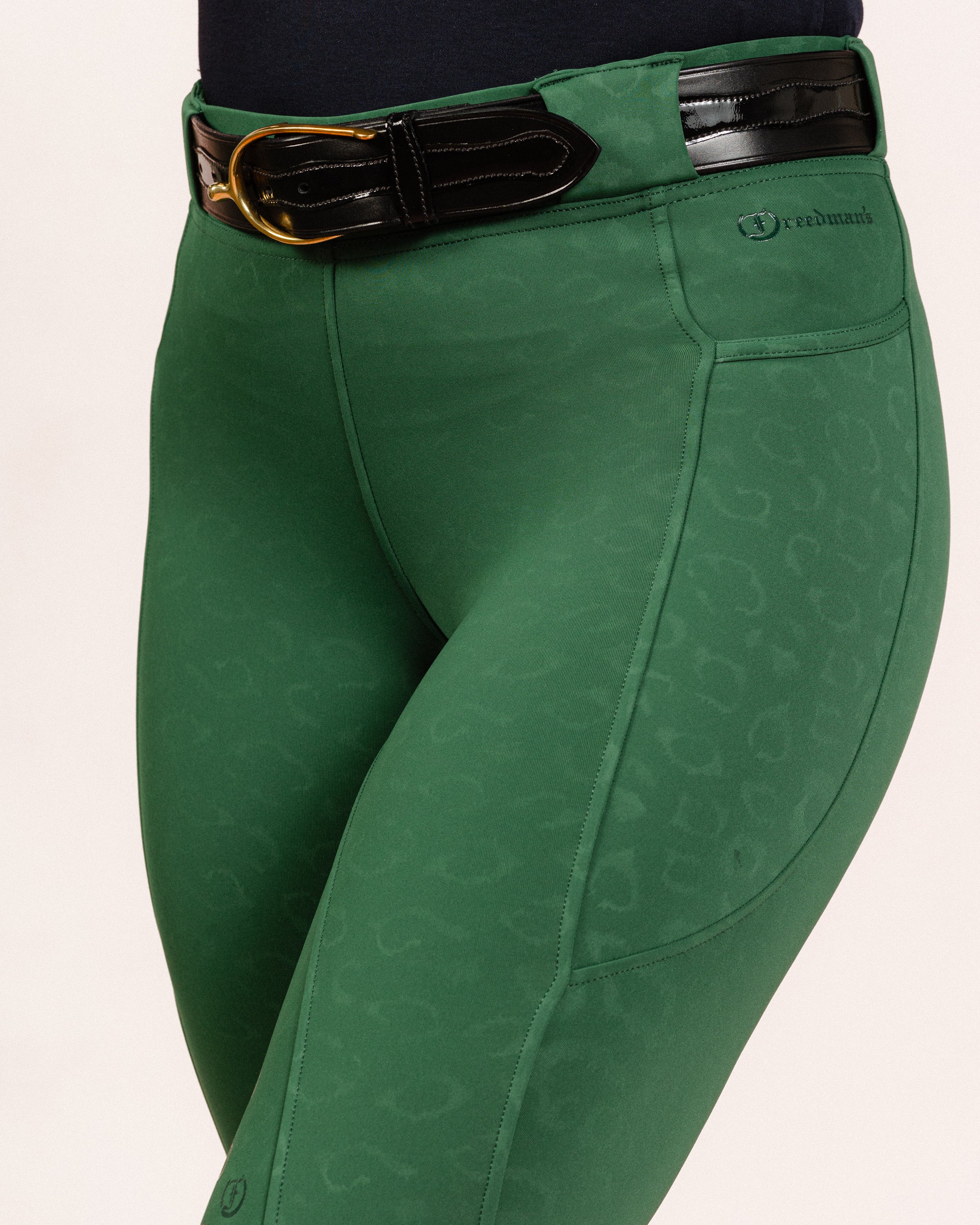 Green Cheetah Jods showing the “Freedman’s” logo with a Patent Scalloped Spur Black Belt on a white background, made by Freedman’s Harness.