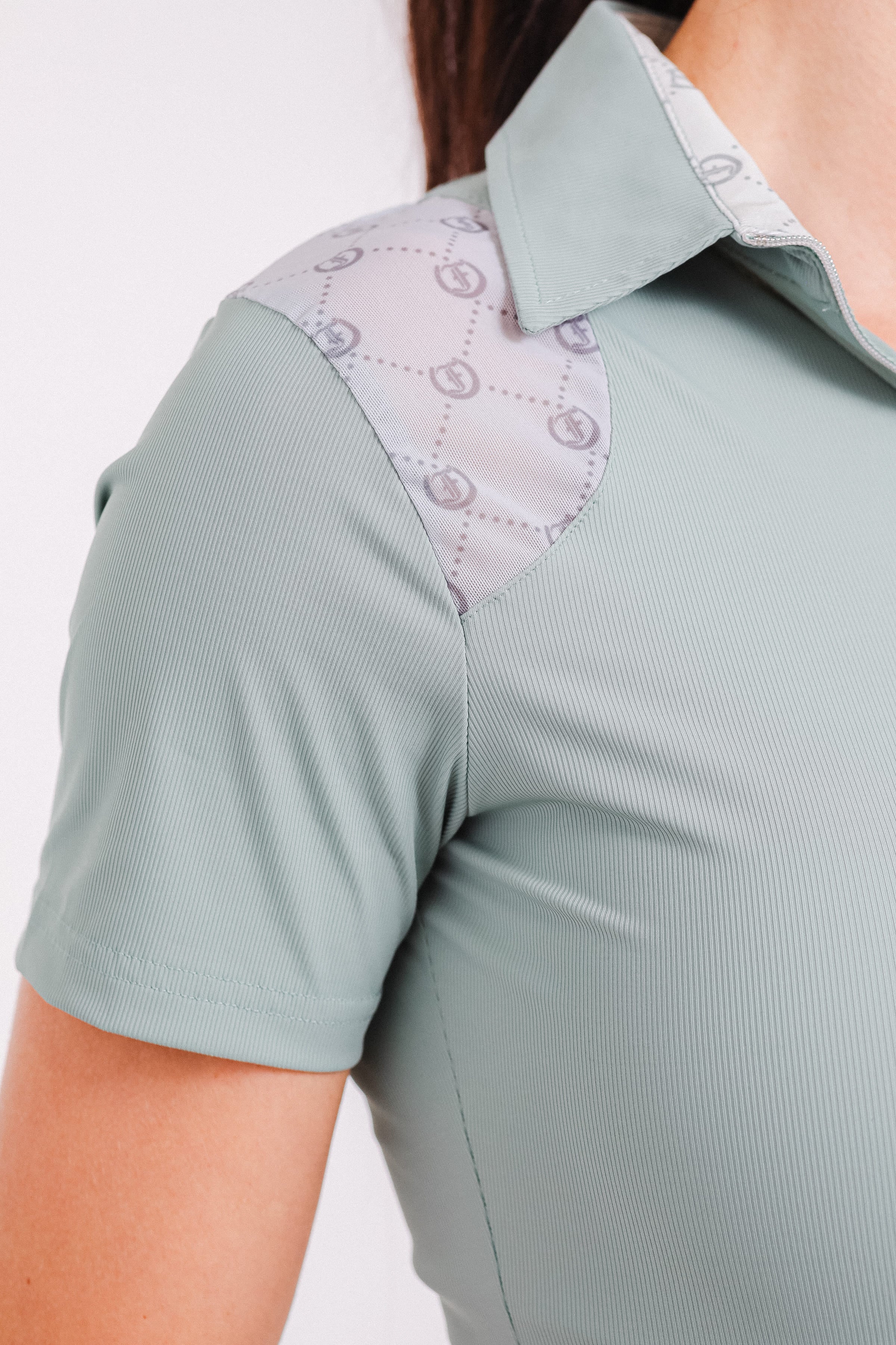 Light green Ladies' 1/4 Zip Polo by Freedman's, close-up of collar and patterned mesh shoulder panel.