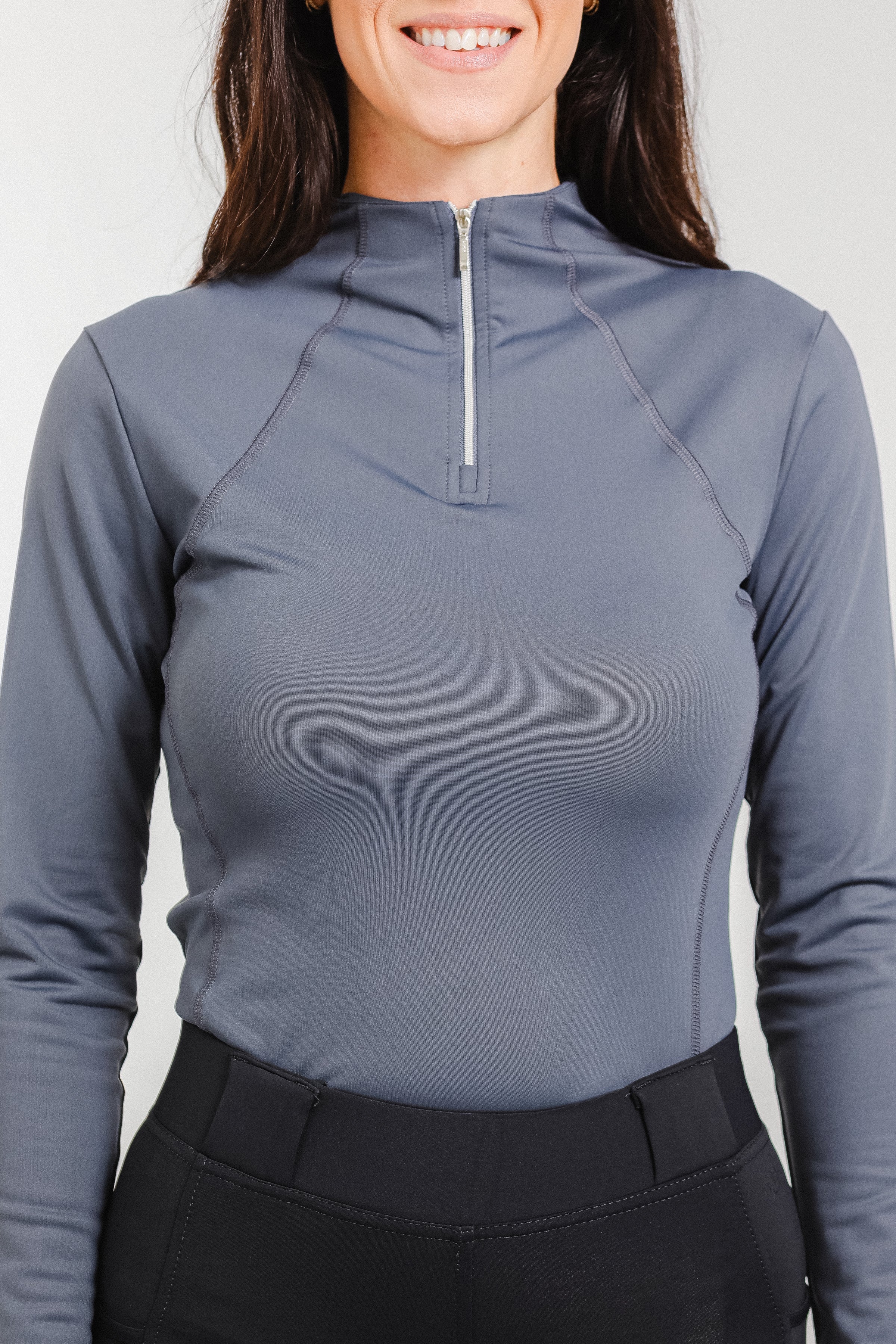 Woman wearing the Tess Ladies' 1/4 Zip Long Sleeve Top by Freedman's in a stylish grey colour, designed for comfort and performance in equestrian and activewear fashion.
