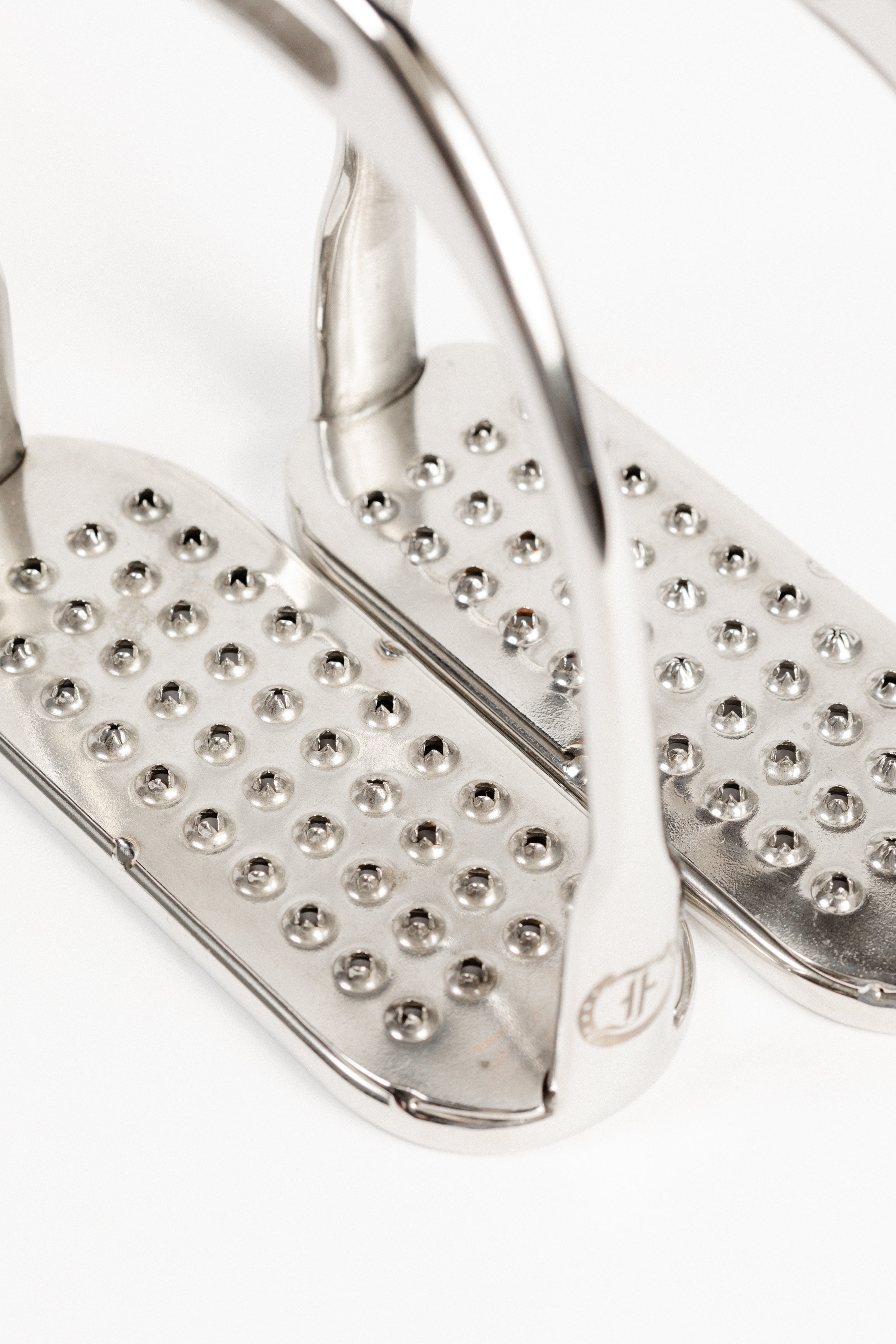 Close-up of Freedman's Logo Hunter Stirrup Irons, showing permanent pick stainless steel treads and brand logo detail.