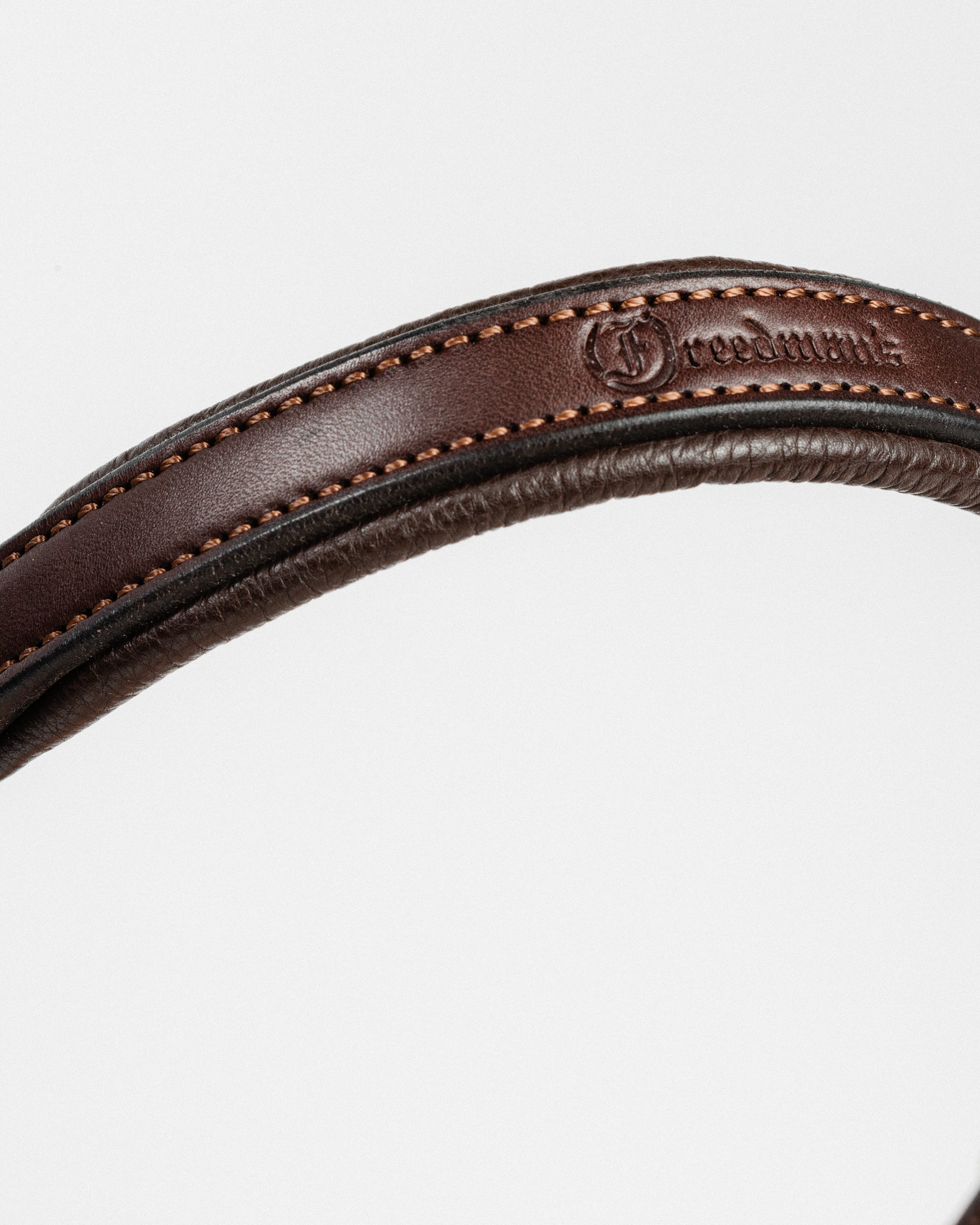 Close-up of a dark brown leather strap with brass buckle, showcasing the fine stitching and the "Freedman" brand embossed on the leather.