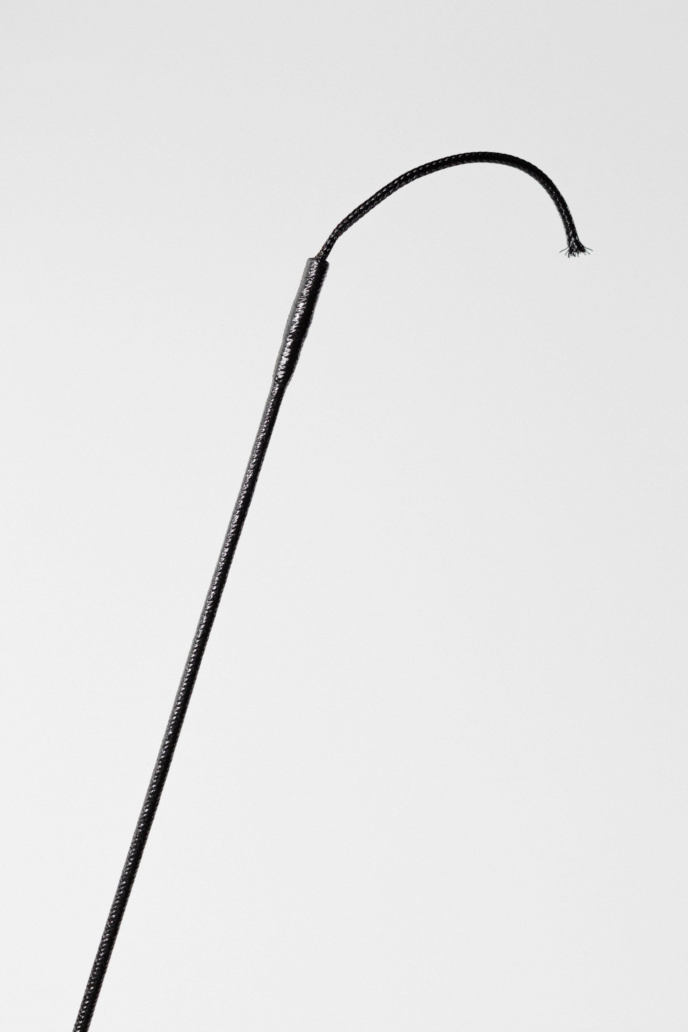 Partial view of a Black Grippy Handle Show Crop with Rhinestone Handle, showing the shaft and part of the grip.