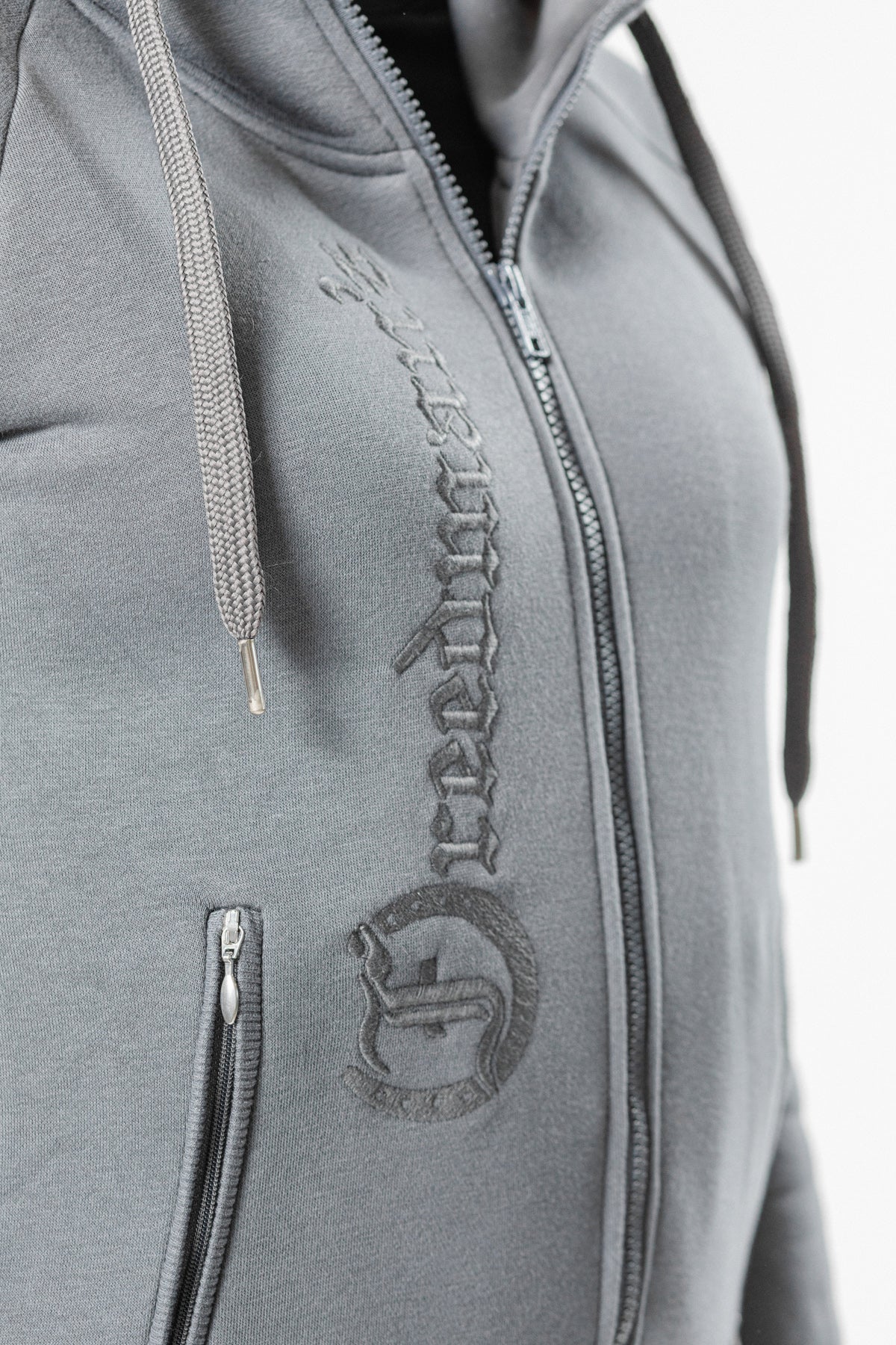 Ash Grey Ladies' Logo Hoodie by Freedman's, close-up showing embroidered "Freedman's" logo down the front and full zip closure.