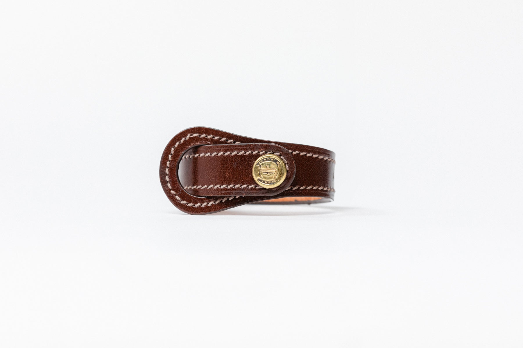 Brown leather Signature Leather Bracelet by Freedman's with brass logo button and white stitching, displayed on a white background.