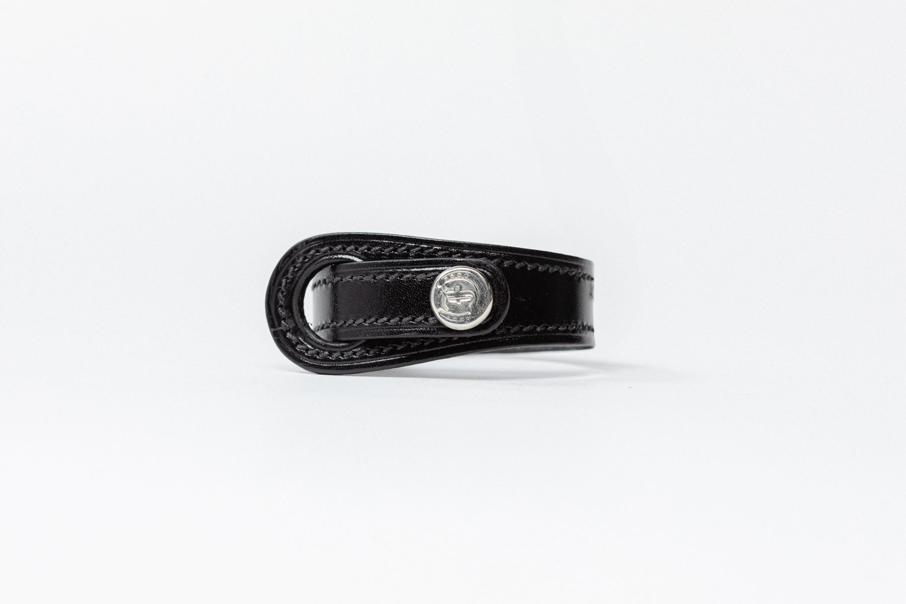 Black leather Signature Leather Bracelet by Freedman's with silverlogo button and white stitching, displayed on a white background