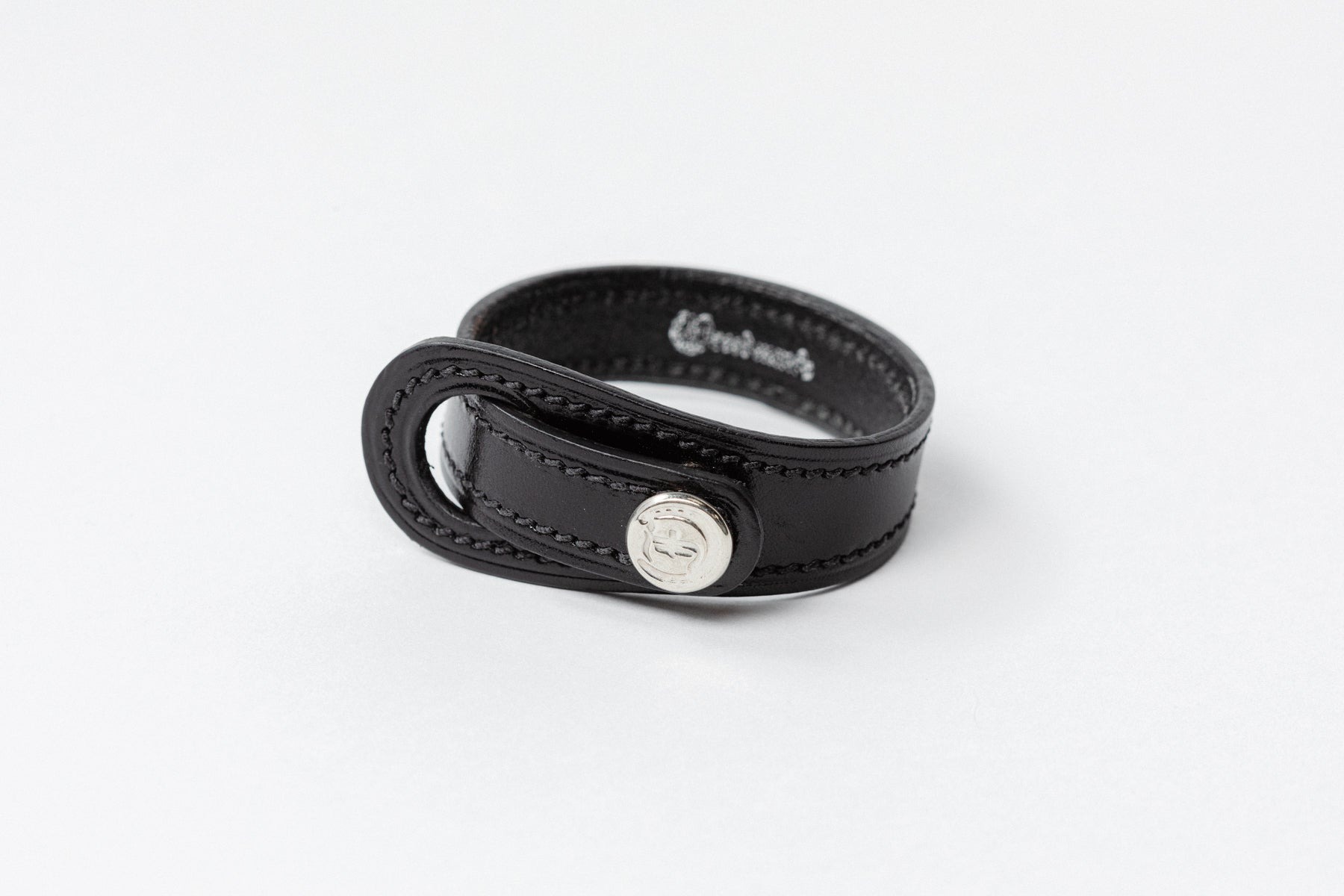 Black leather Signature Leather Bracelet by Freedman's with silver logo button and white stitching, displayed on a white background.