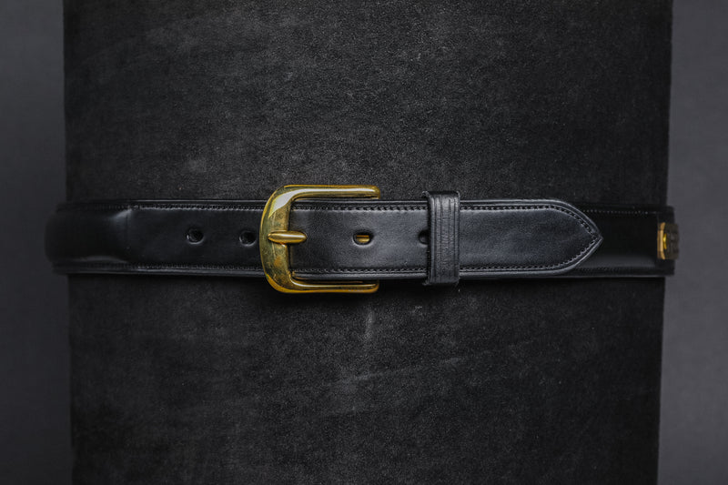 Close-up of Raised Custom Name Plate Belt in Black leather with brass buckle and stitched detail.
