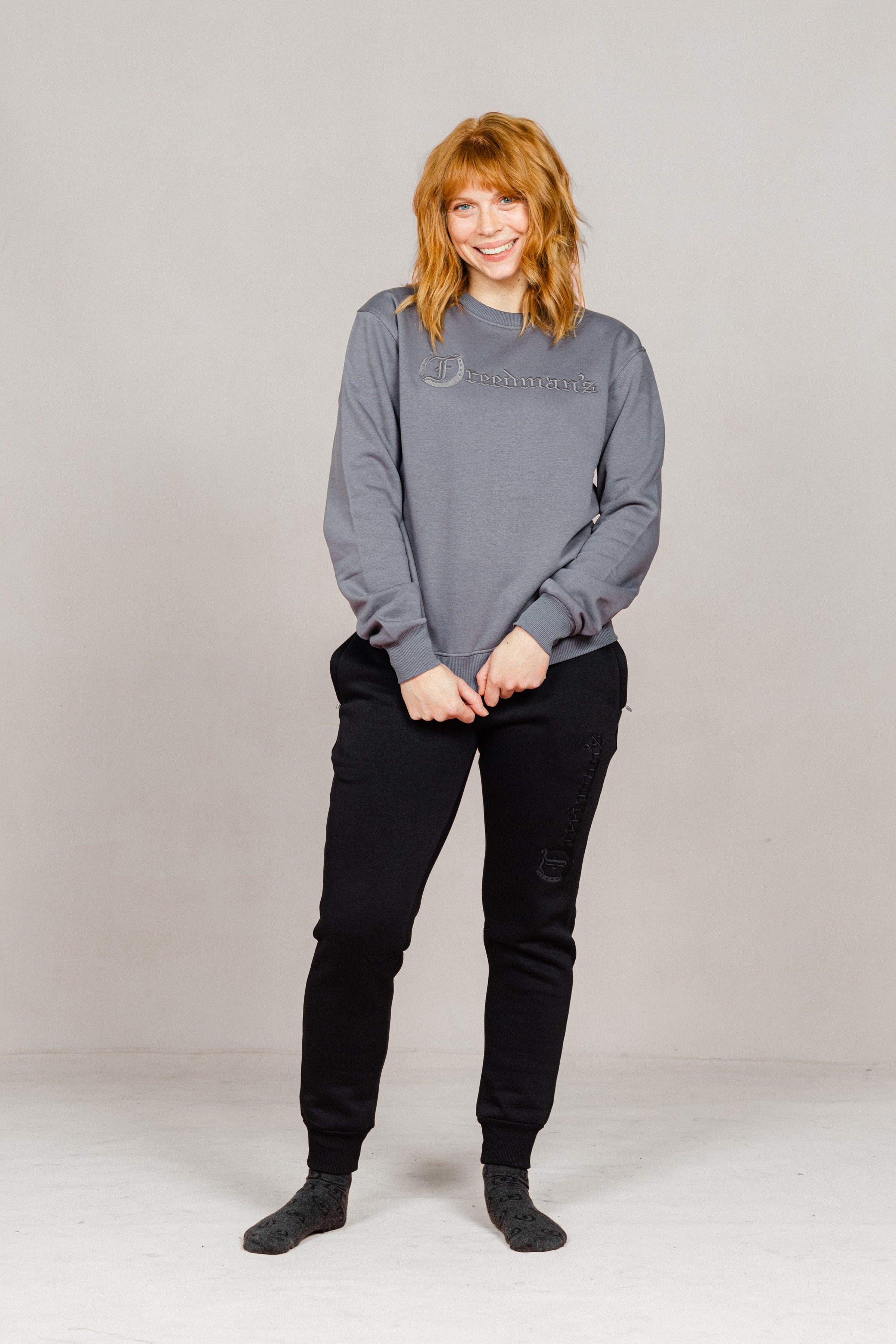Woman wearing the Ash Grey Freedman's embroidered crewneck sweatshirts. These stylish and cozy sweatshirts feature a tonal Freedman’s logo, perfect for casual wear and layering