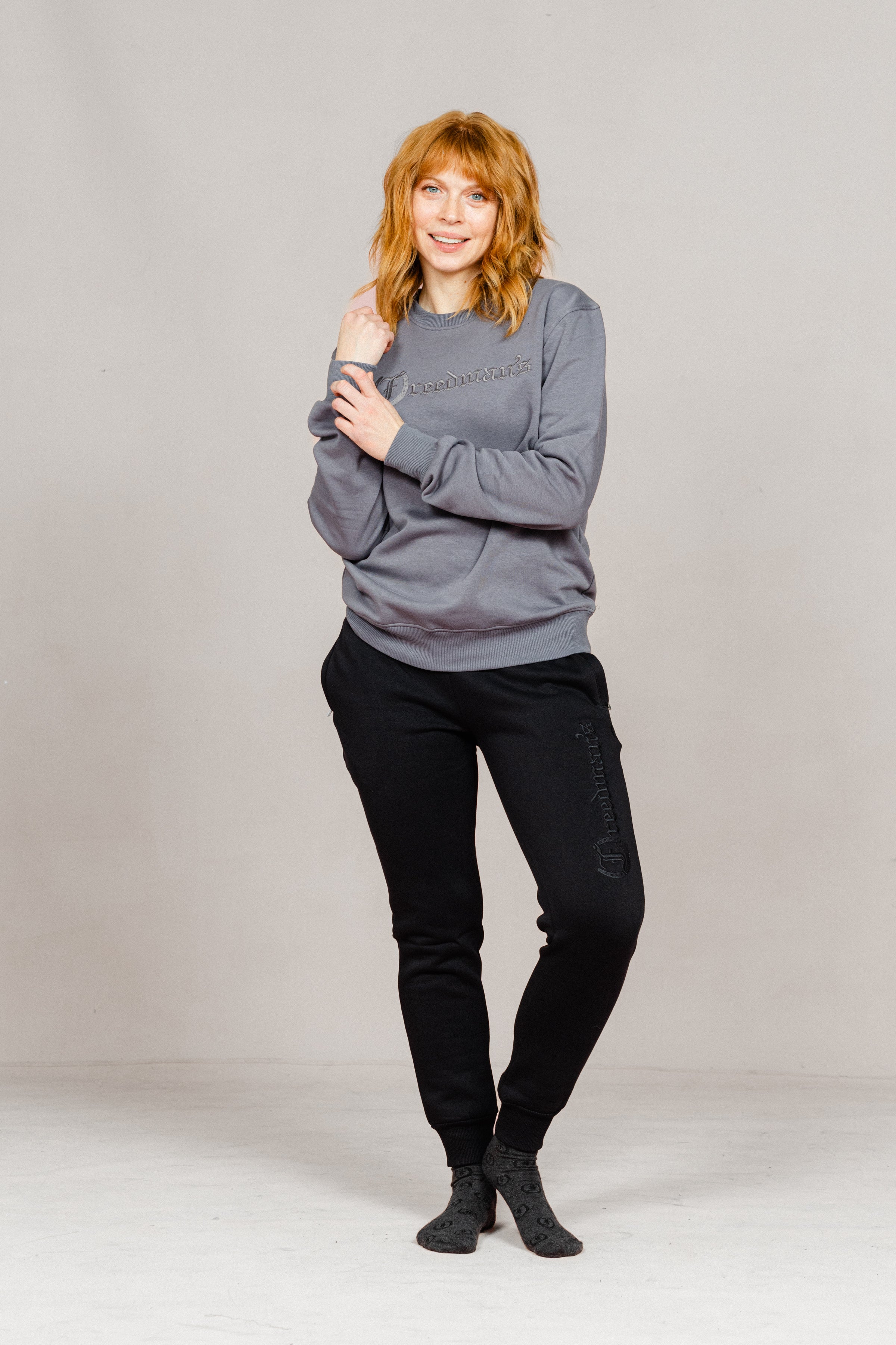 Woman wearing the Ash Grey Freedman's embroidered crewneck sweatshirts. These stylish and cozy sweatshirts feature a tonal Freedman’s logo, perfect for casual wear and layering