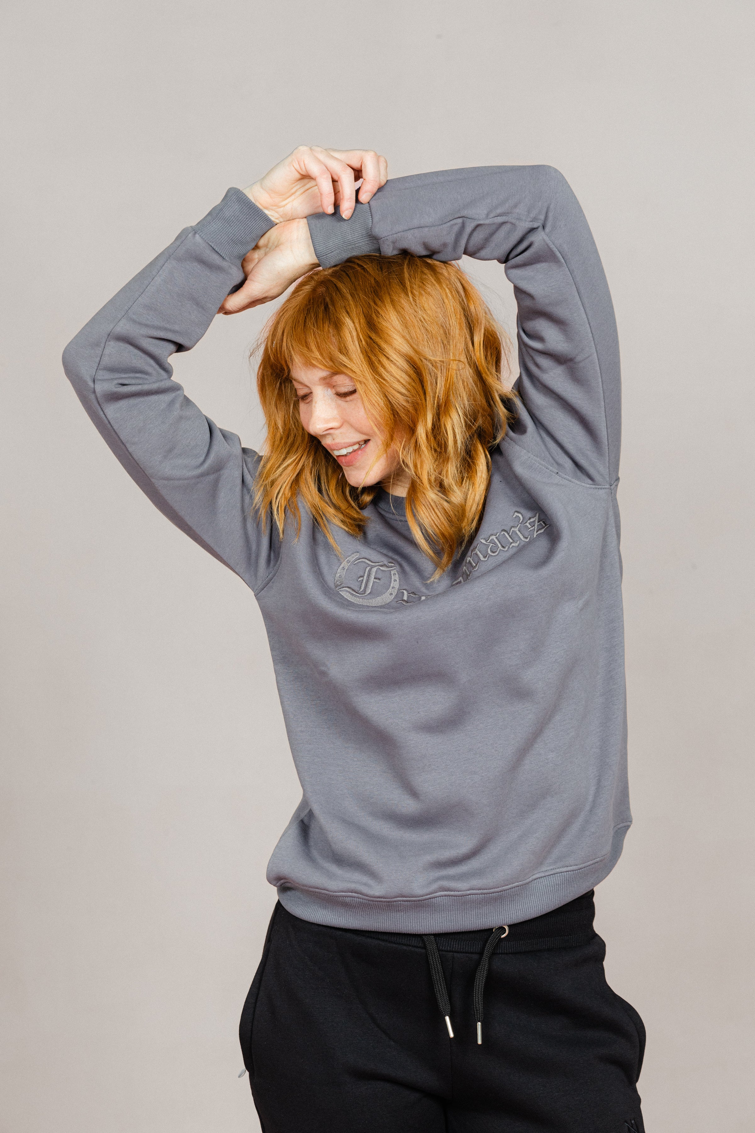 Woman wearing the Ash Grey Freedman's embroidered crewneck sweatshirts. These stylish and cozy sweatshirts feature a tonal Freedman’s logo, perfect for casual wear and layering
