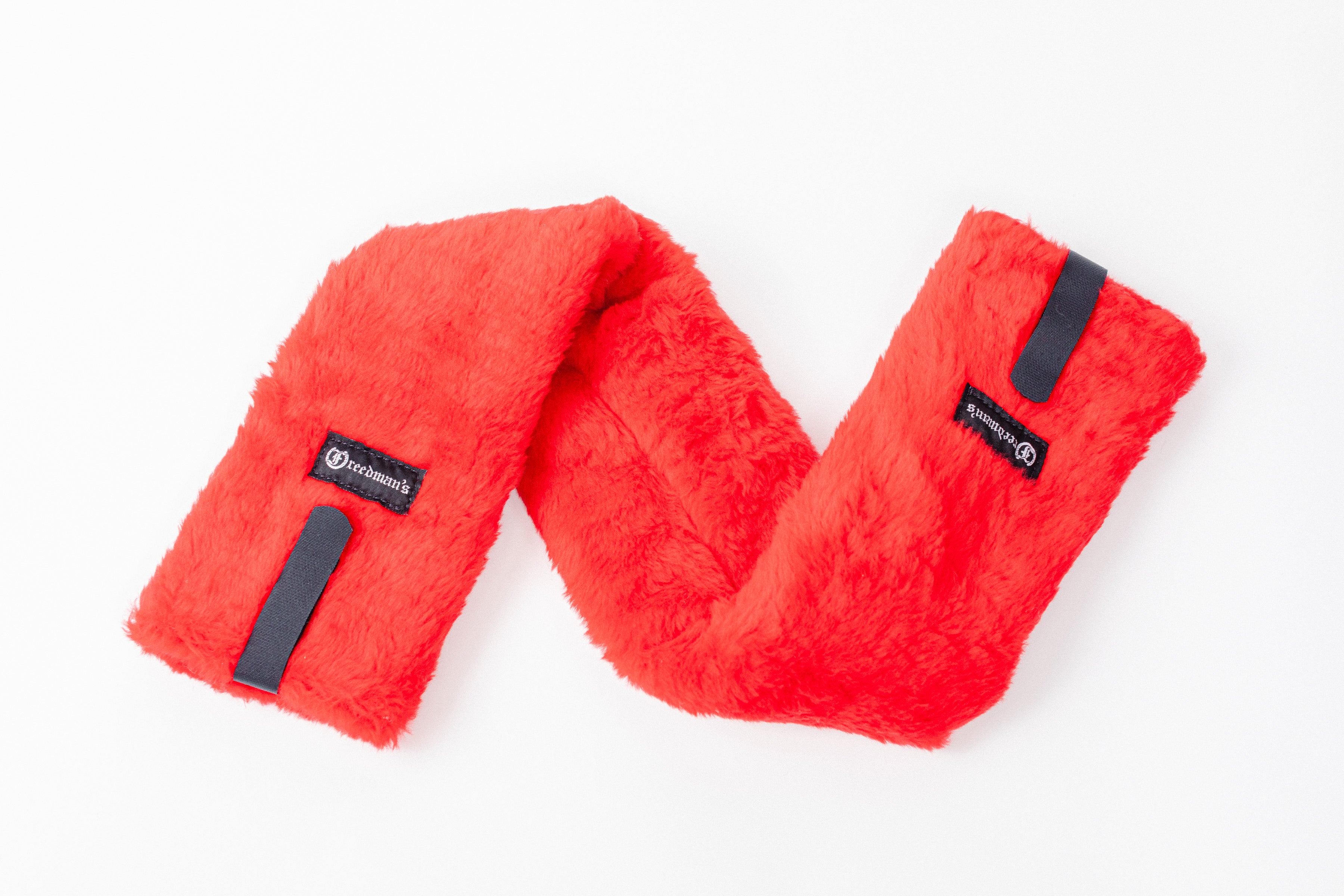 Close-up of Freedman's Fleece Breast Collar Pad, red fabric with logo patches, equestrian equipment.