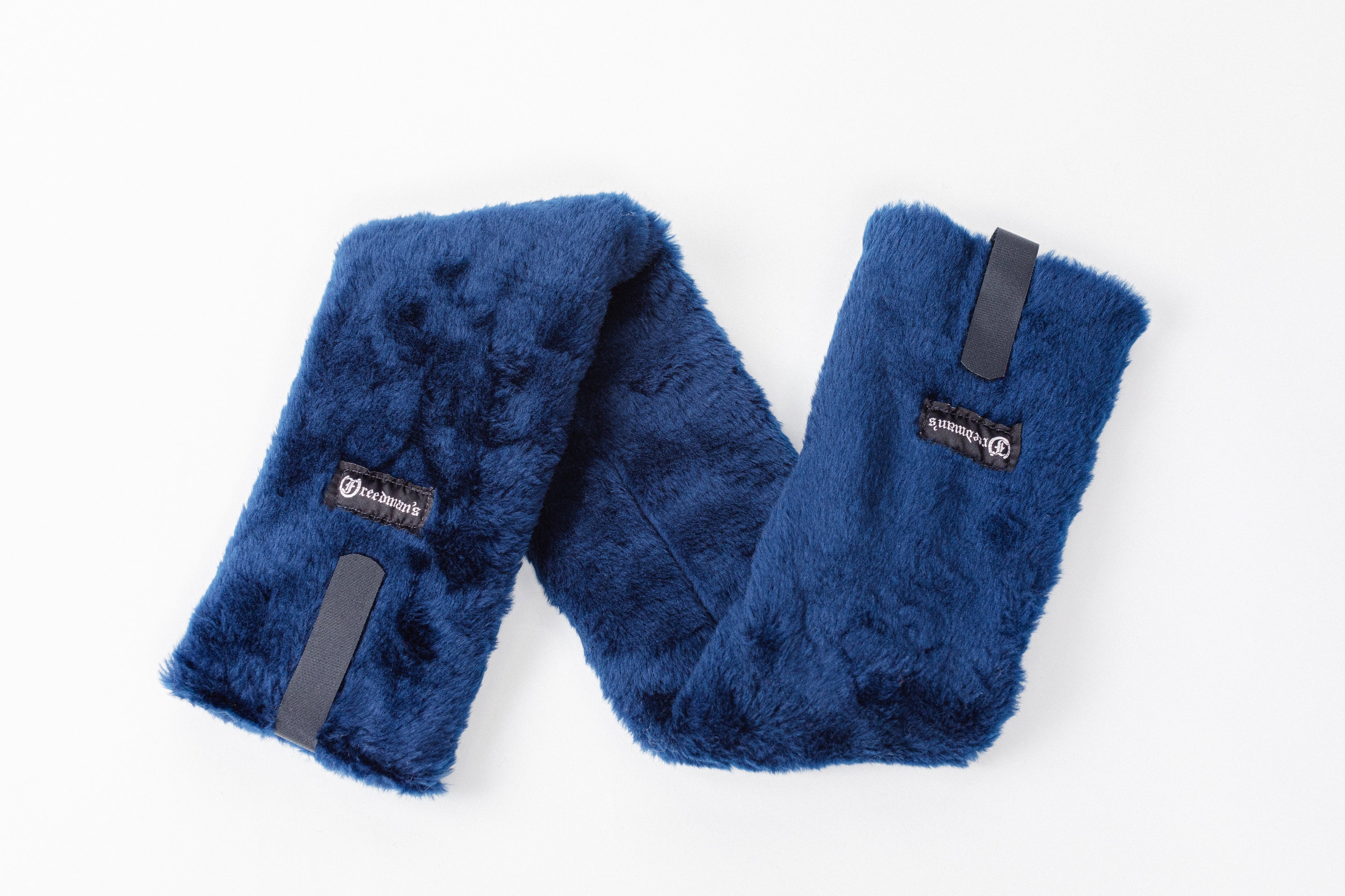 Close-up of Freedman's Fleece Breast Collar Pad, navy blue fabric with logo patches, equestrian equipment.