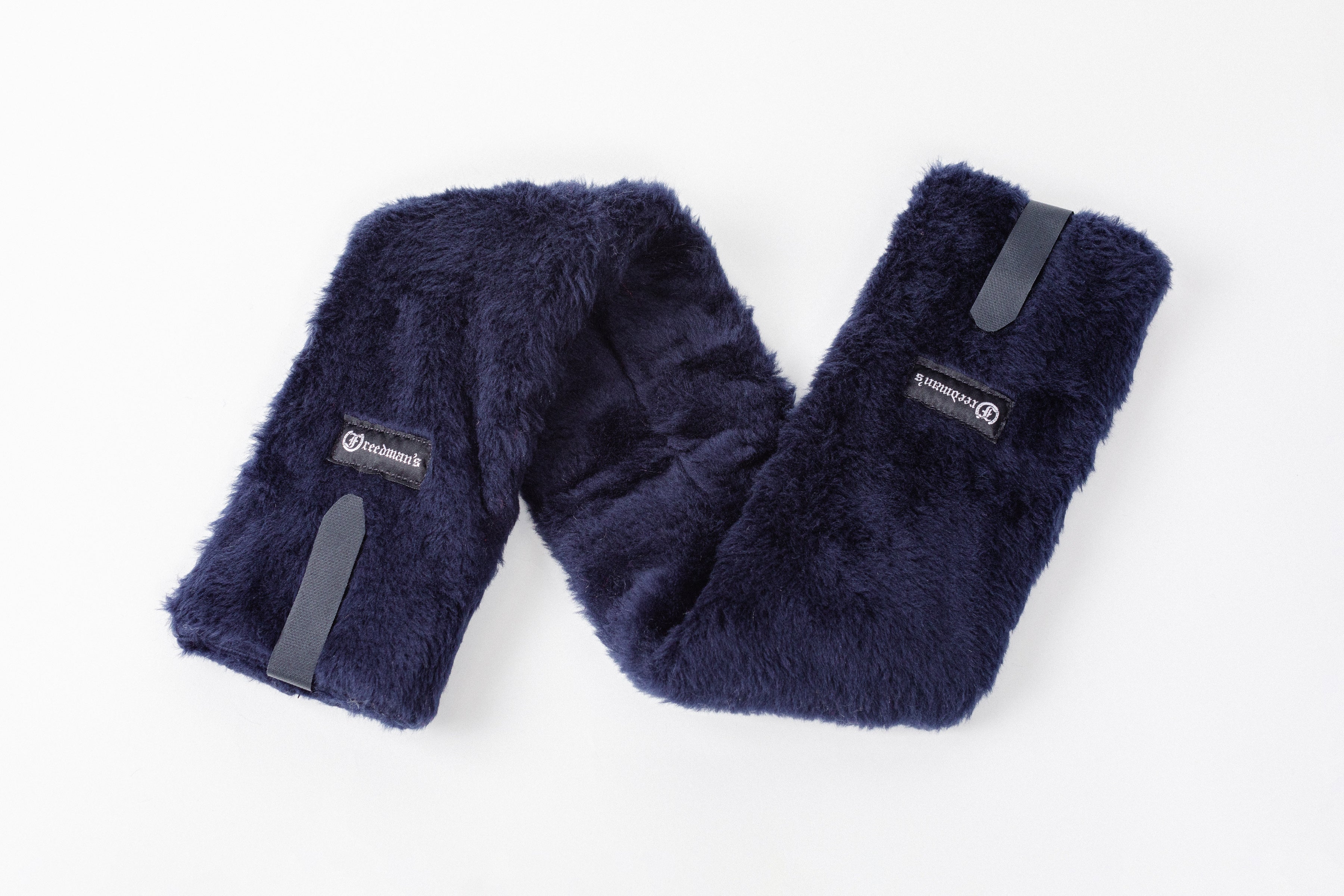 Close-up of Freedman's Fleece Breast Collar Pad, dark blue fabric with logo patches, equestrian equipment.