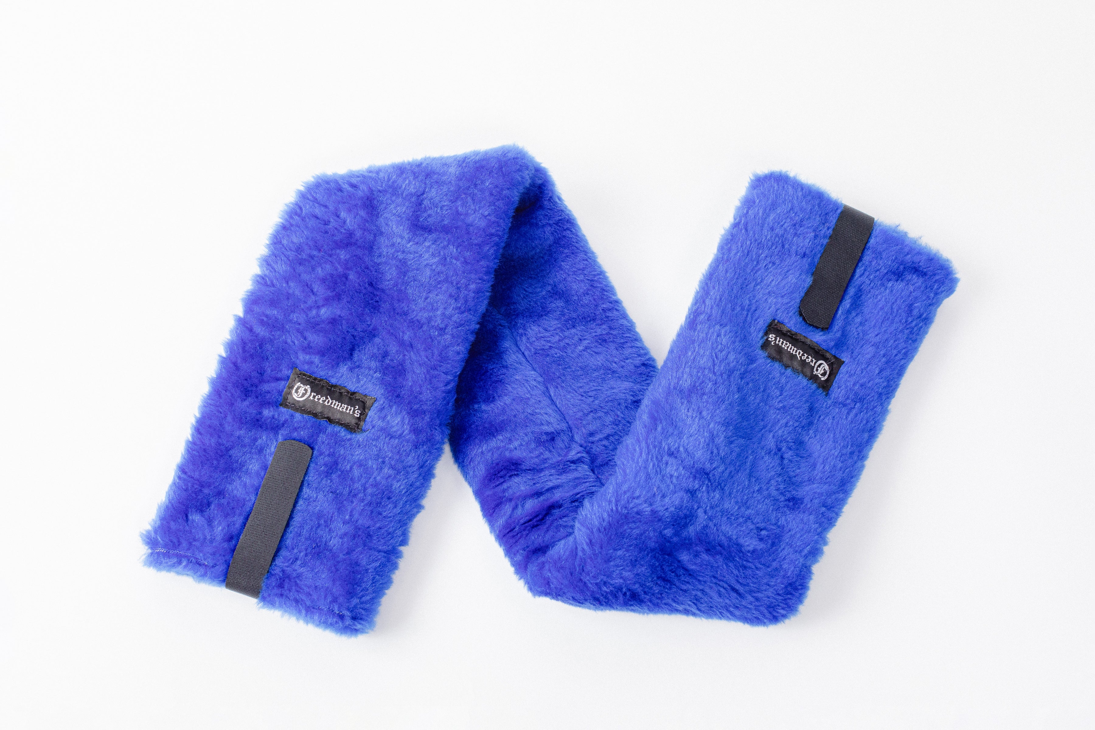 Close-up of Freedman's Fleece Breast Collar Pad, blue fabric with logo patches, equestrian equipment.
