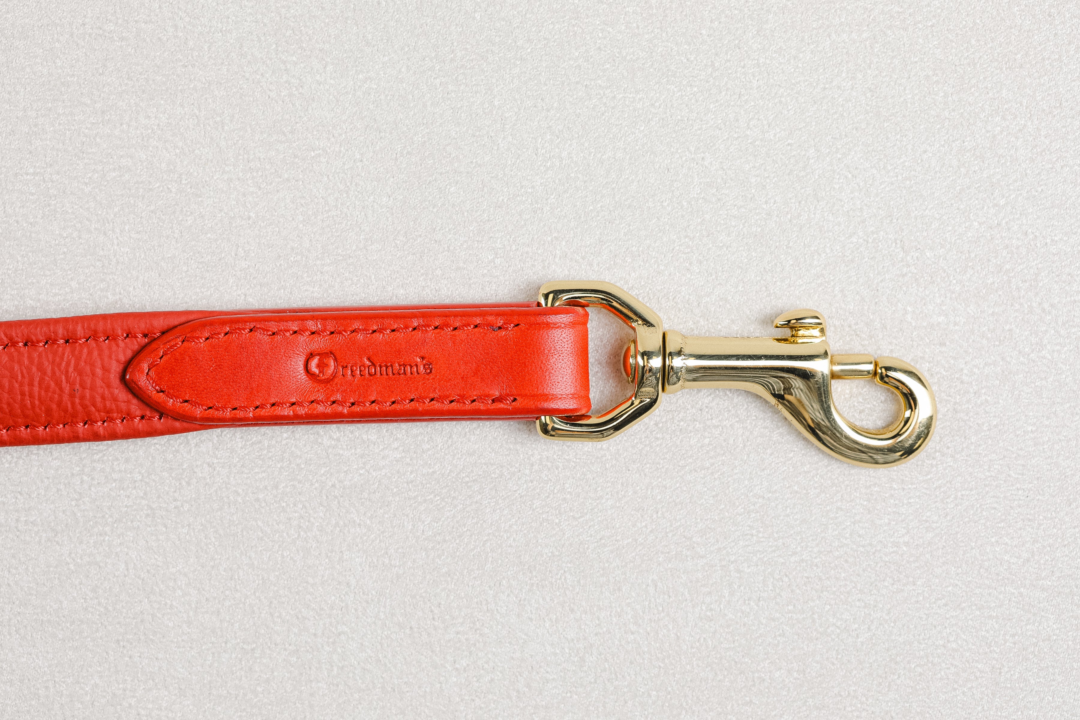 Close-up of a Raised Dog Leash showcasing the brass snaps with Freedman's logo stamped on leather.