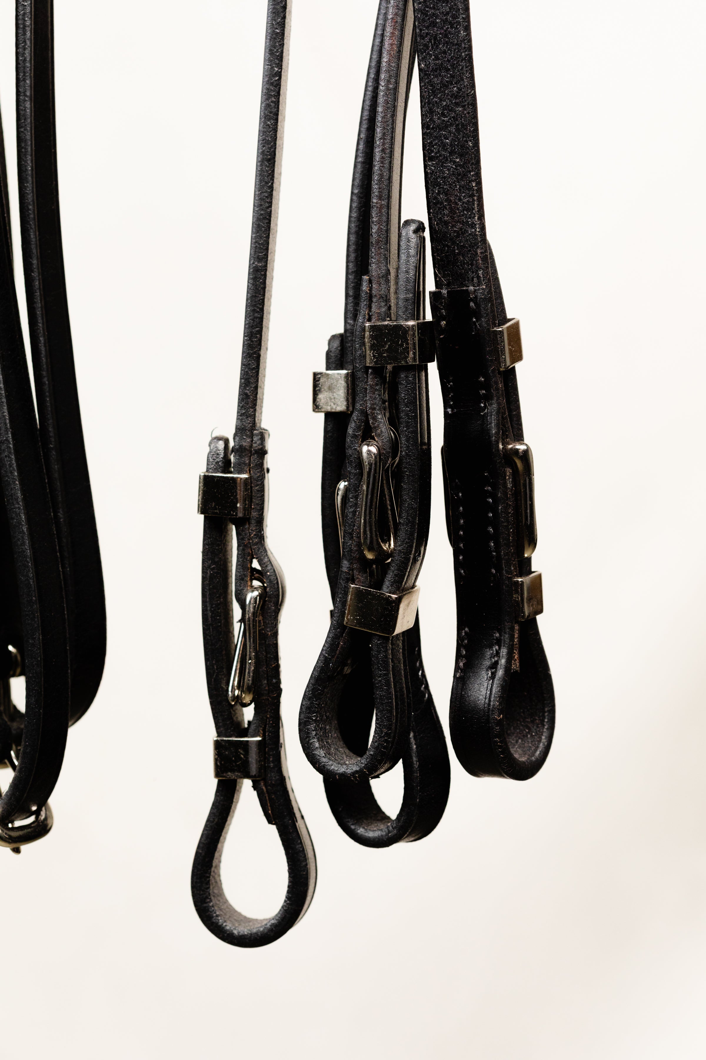 Close-up of Black Leather Reins with Buckle Attachments for Horse Bridle