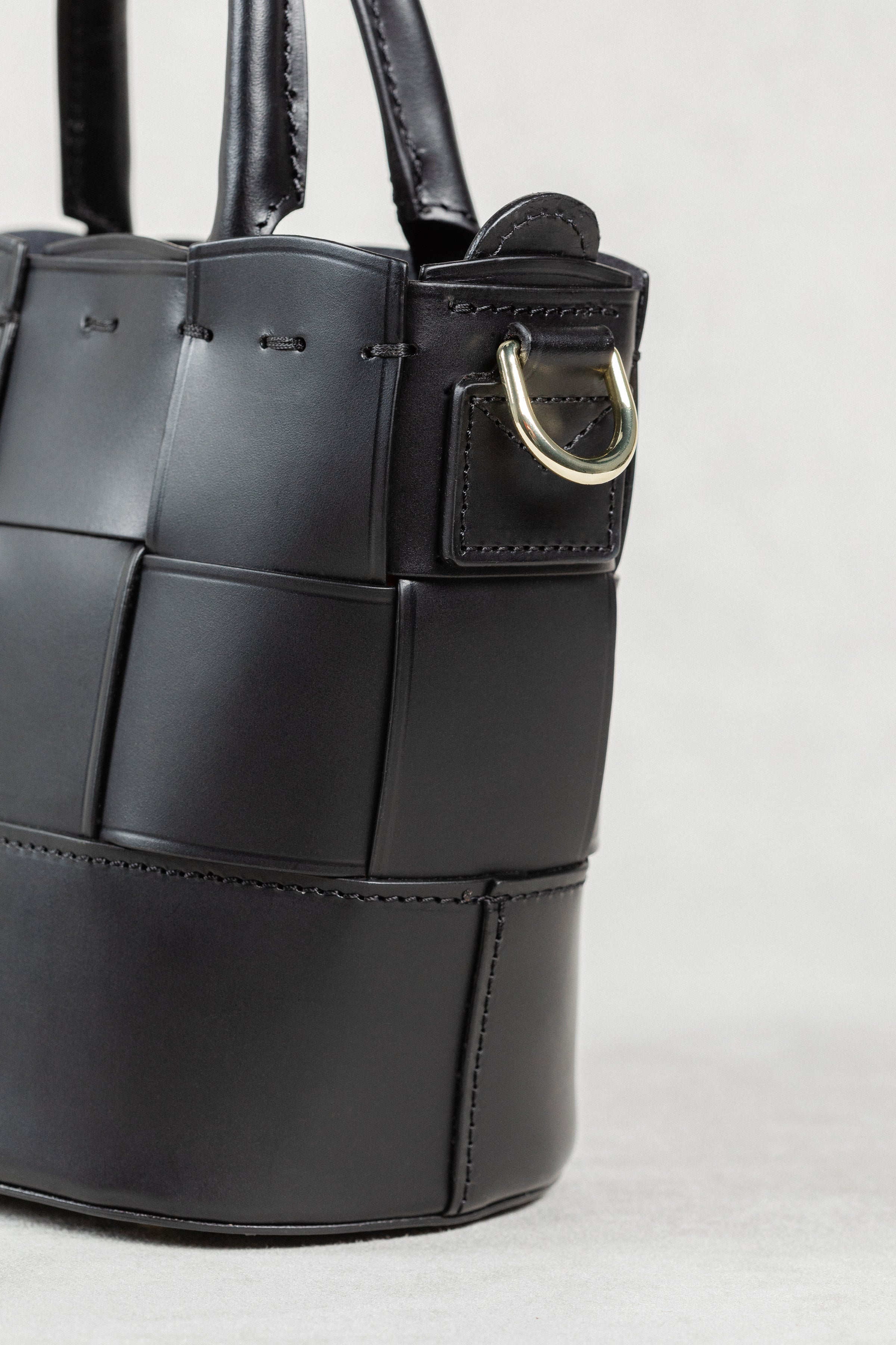 Close-up of black leather Milord Bag by Freedman's, highlighting gold-tone hardware and construction details.