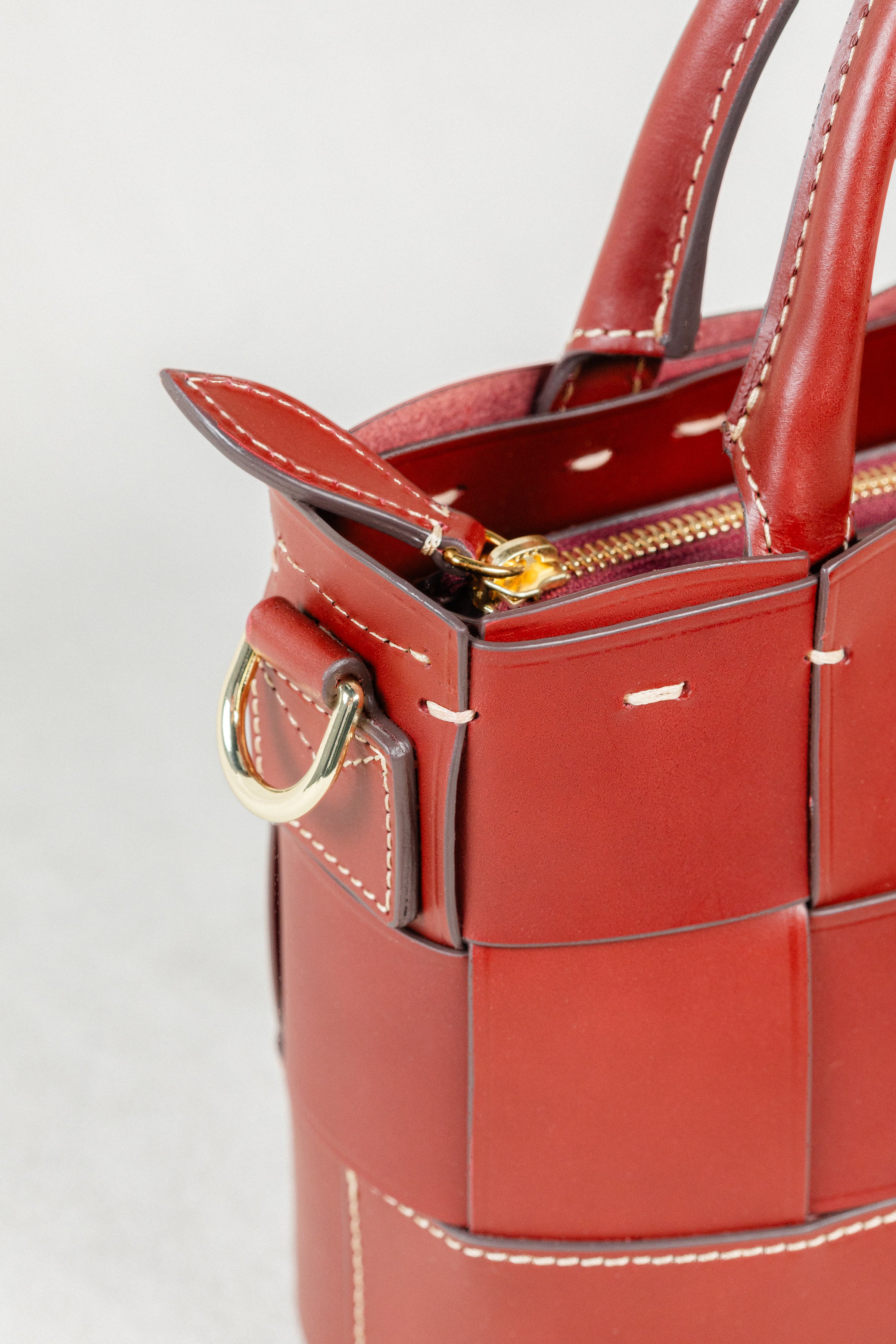 Close-up of Brunello leather Milord Bag by Freedman's, highlighting gold-tone zipper, ring hardware, and handle stitching.