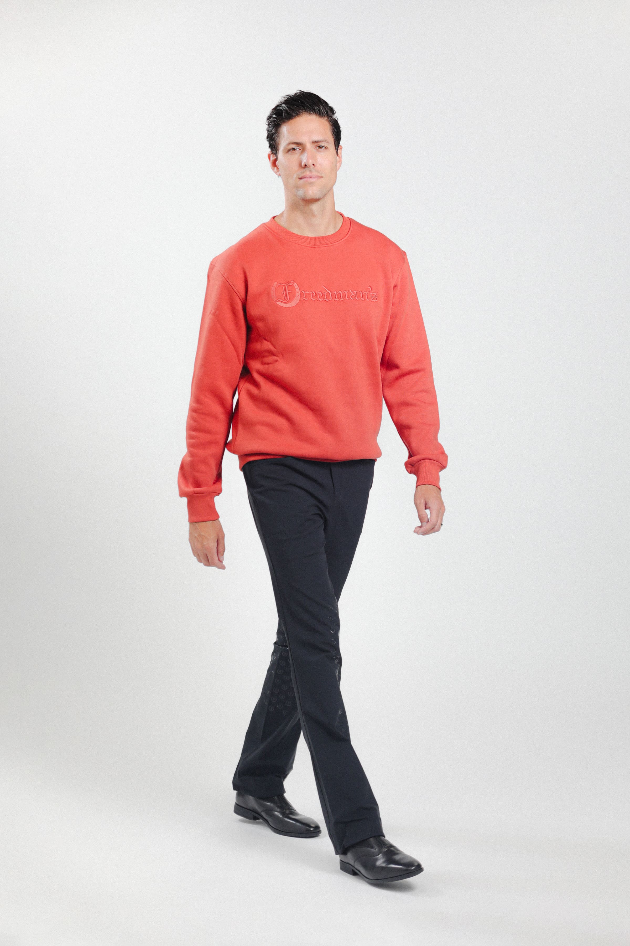 Man wearing Freedman's embroidered crewneck sweatshirts in Brick Red. These stylish and cozy sweatshirts feature a tonal Freedman’s logo, perfect for casual wear and layering