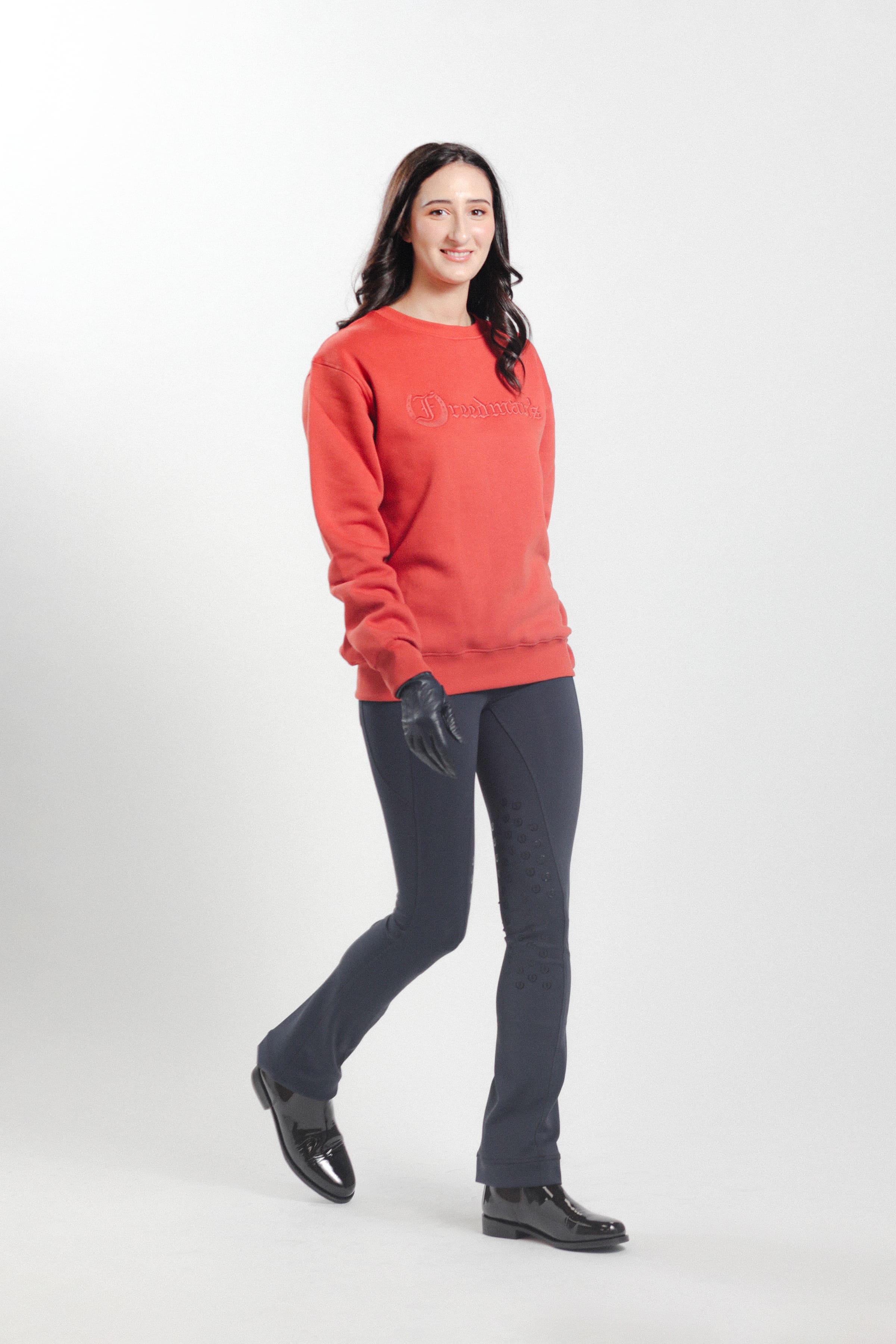 Woman wearing the Brick Red Freedman's embroidered crewneck sweatshirts. These stylish and cozy sweatshirts feature a tonal Freedman’s logo, perfect for casual wear and layering