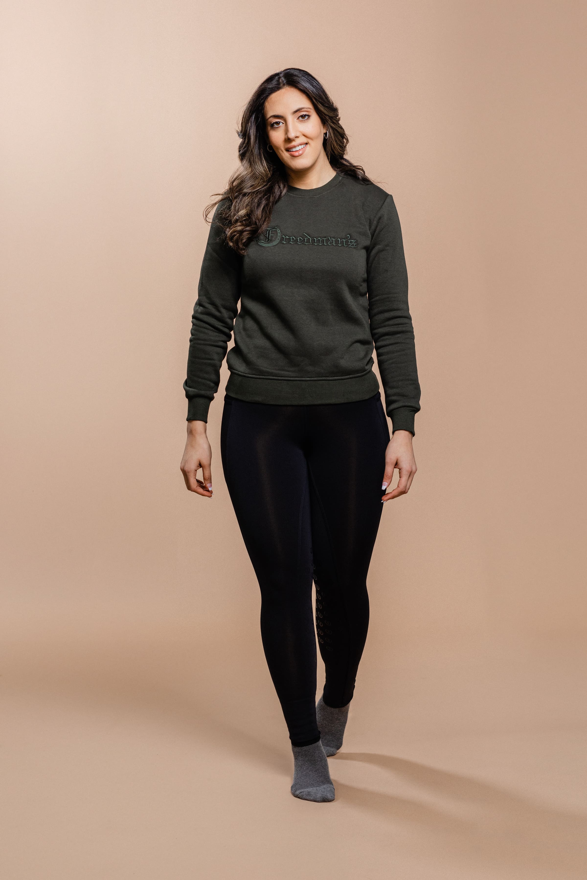 Woman wearing the Olive Green Freedman's embroidered crewneck sweatshirts. These stylish and cozy sweatshirts feature a tonal Freedman’s logo, perfect for casual wear and layering