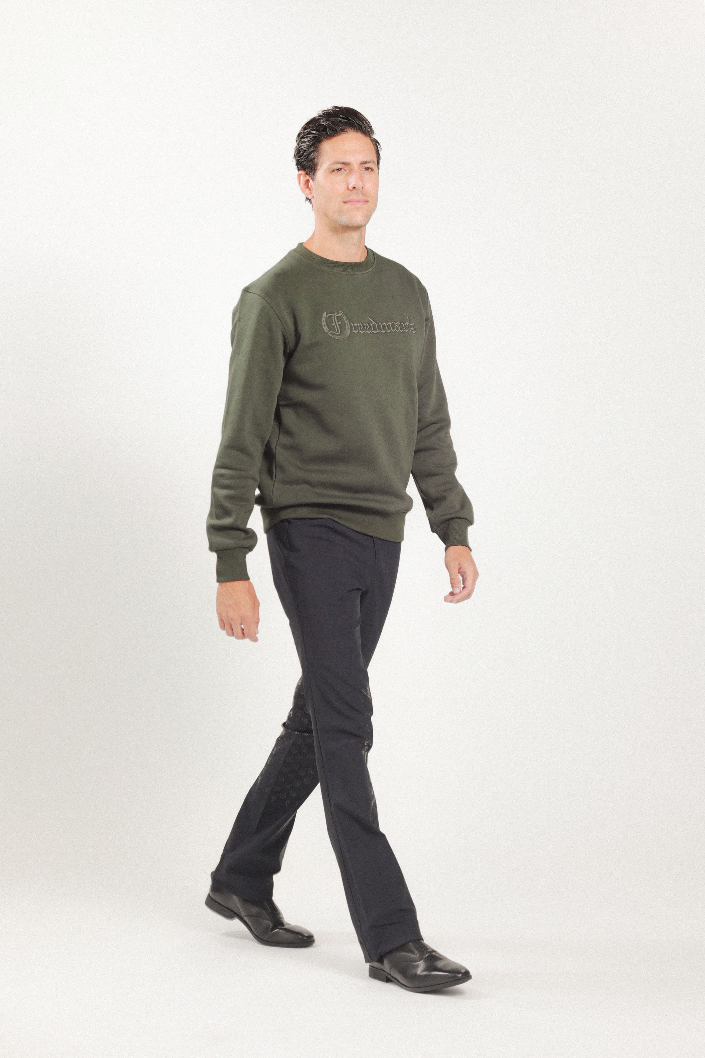 Man wearing Freedman's embroidered crewneck sweatshirts in Green Olive. These stylish and cozy sweatshirts feature a tonal Freedman’s logo, perfect for casual wear and layering