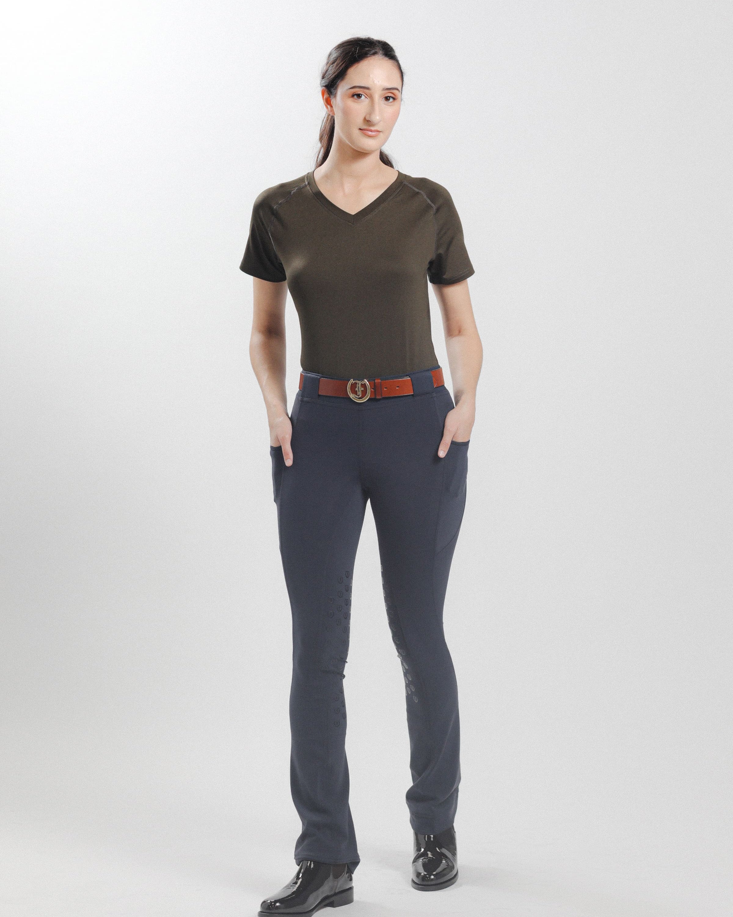 Olive Ladies' Tous les Jours Essential V Neck Tee Shirt, back view showcasing the "Freedman's" print and paired with black jods for an equestrian look.