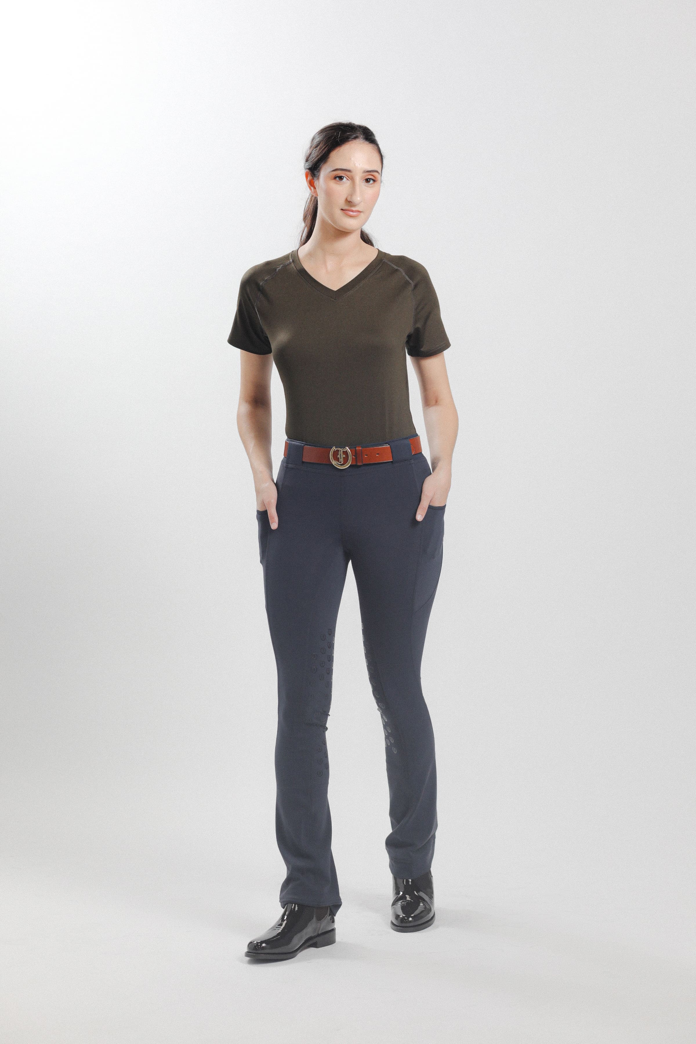 Olive Ladies' Tous les Jours Essential V Neck Tee Shirt, back view showcasing the "Freedman's" print and paired with black jods for an equestrian look.