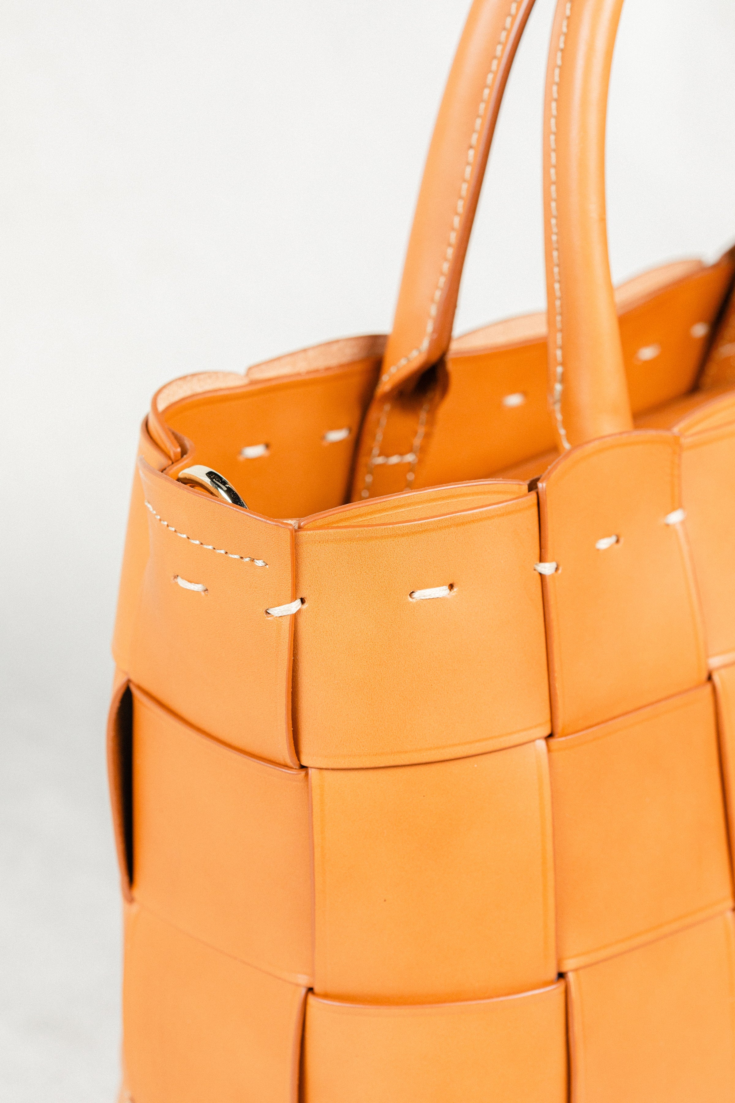 Close-up of cognac Manalos Bag by Freedman's, highlighting the woven leather texture, stitching detail, and handle construction.