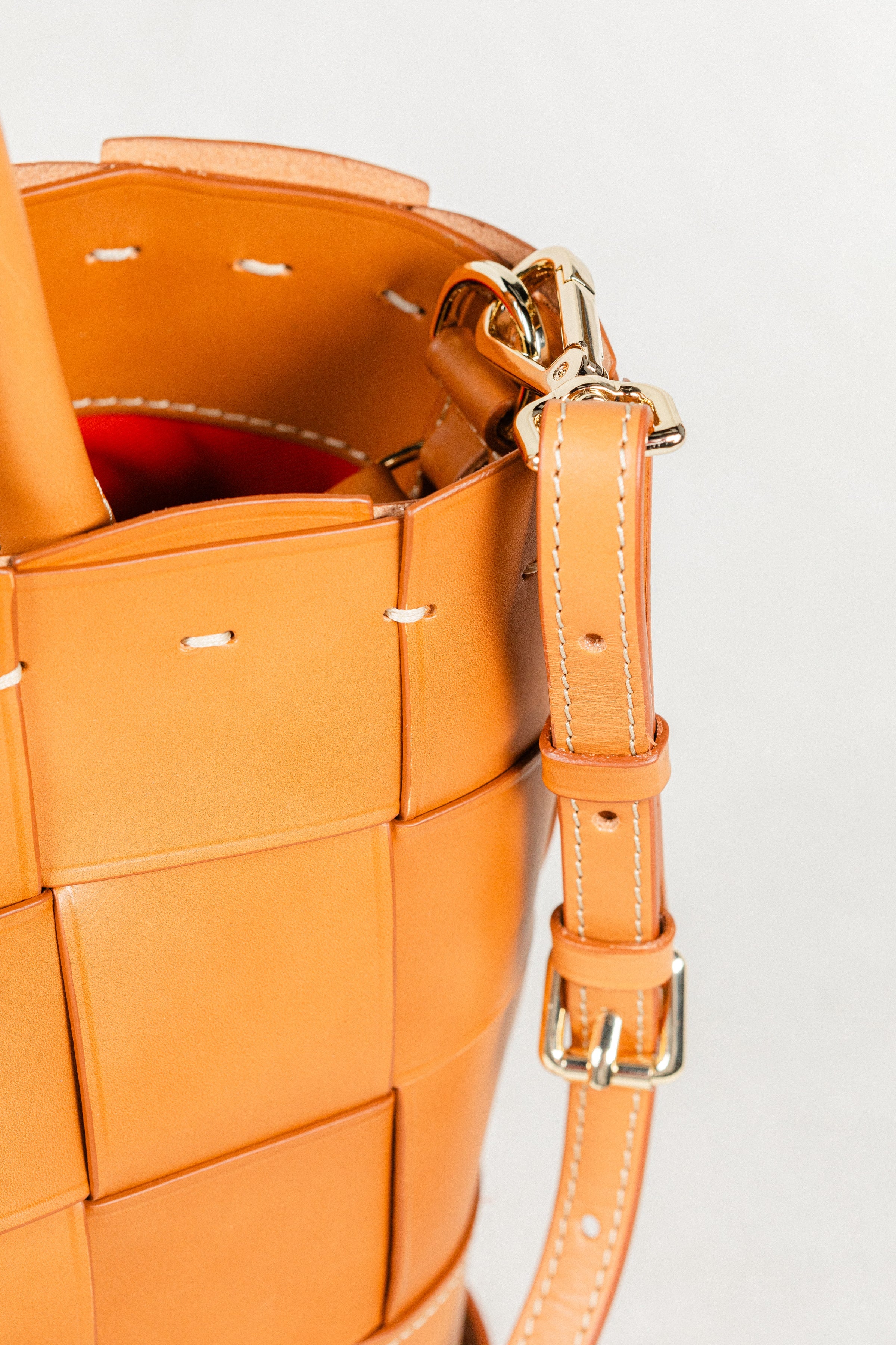 Close-up of cognac Manalos Bag by Freedman's, highlighting gold-tone hardware, adjustable strap, and woven leather detail.