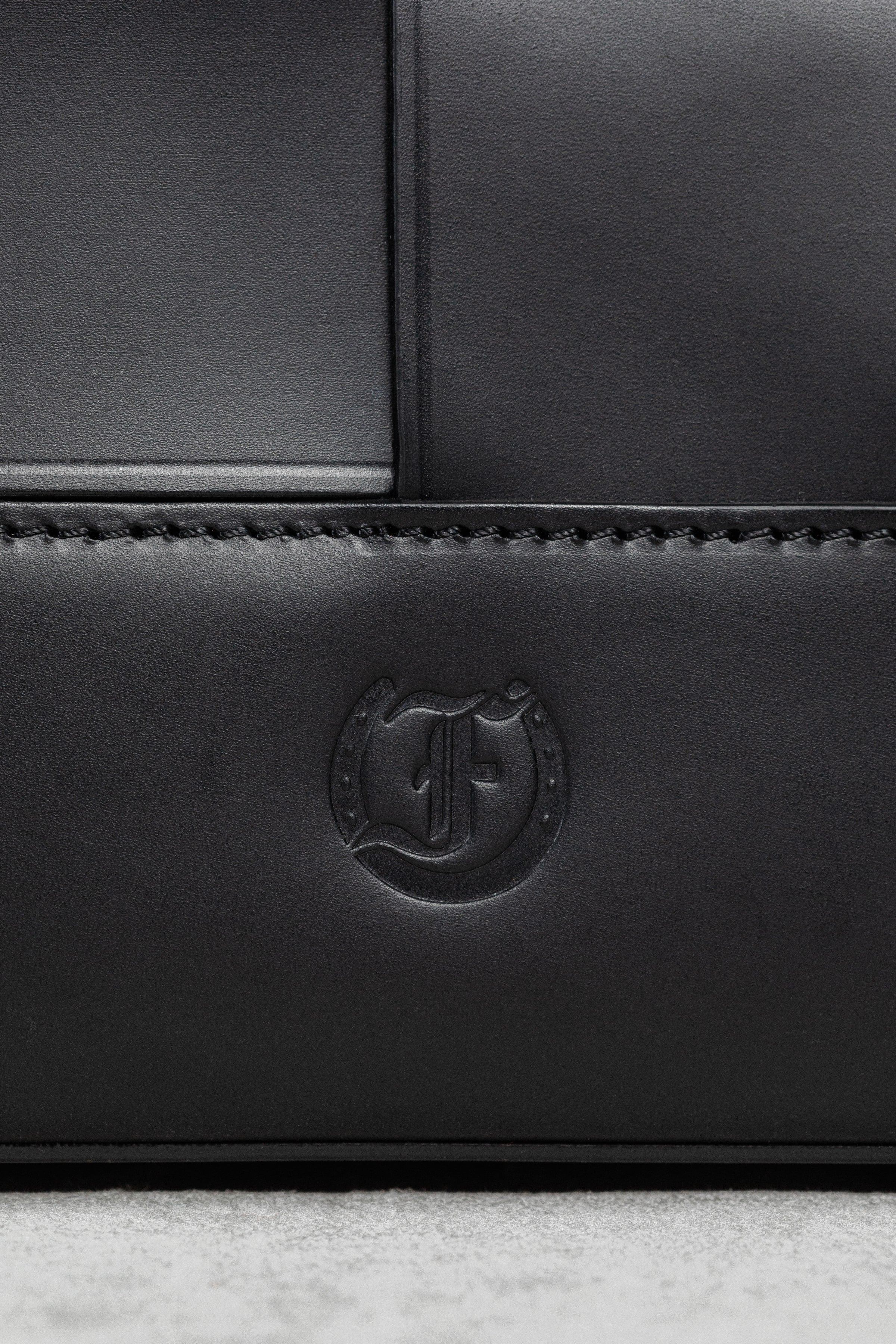 Close-up of Freedman's F logo embossed on the Manalos Bag