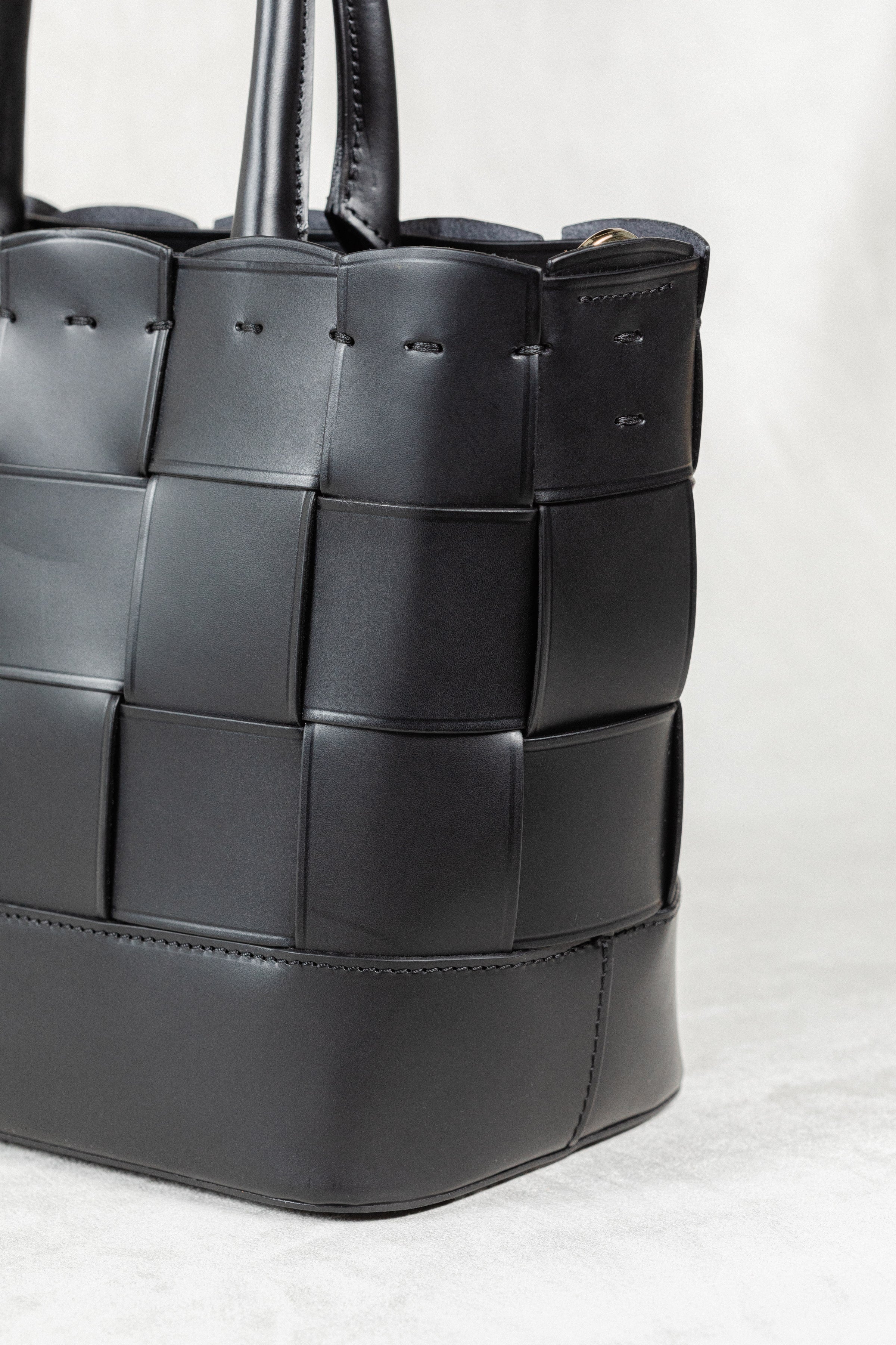 Angled close-up of the black Manalos Bag by Freedman's, highlighting the woven leather texture and stitching detail.