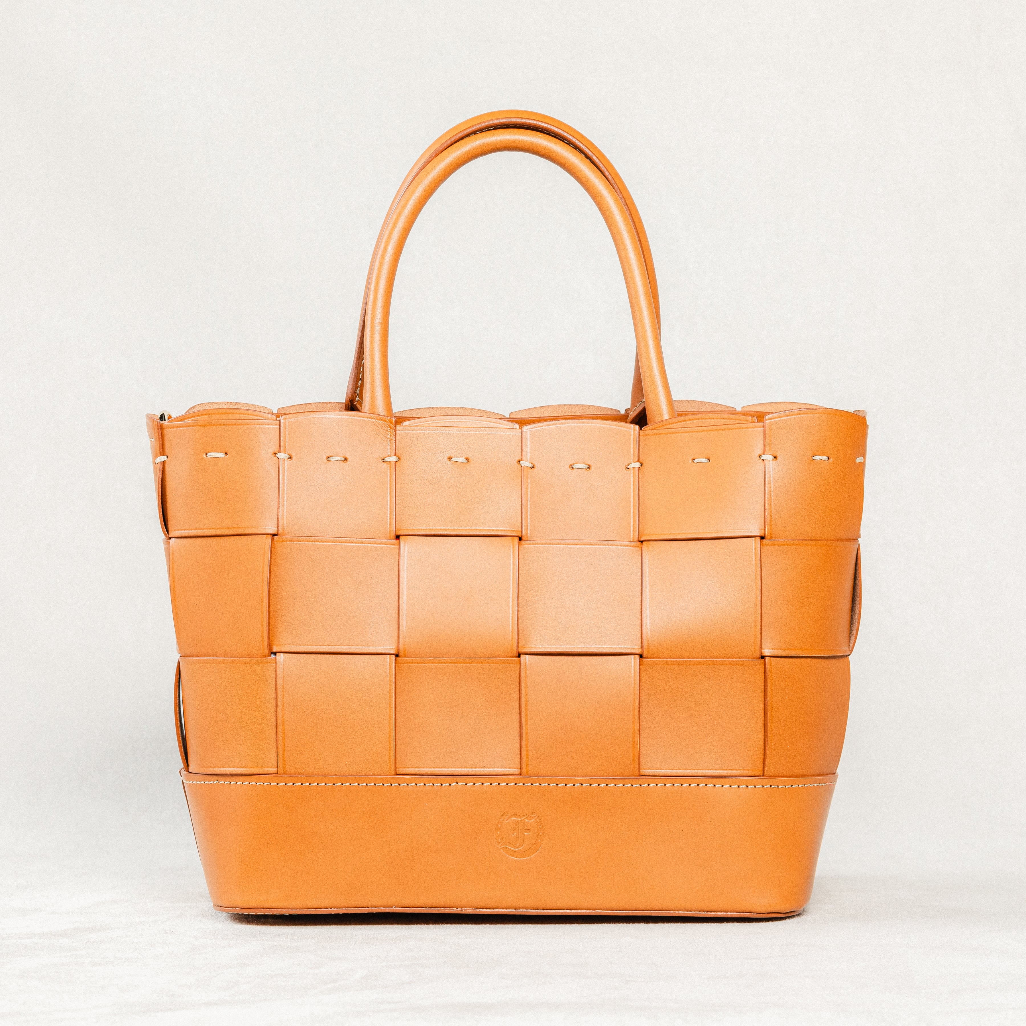 Cognac Manalos Bag by Freedman's, featuring a woven leather design and structured handles.