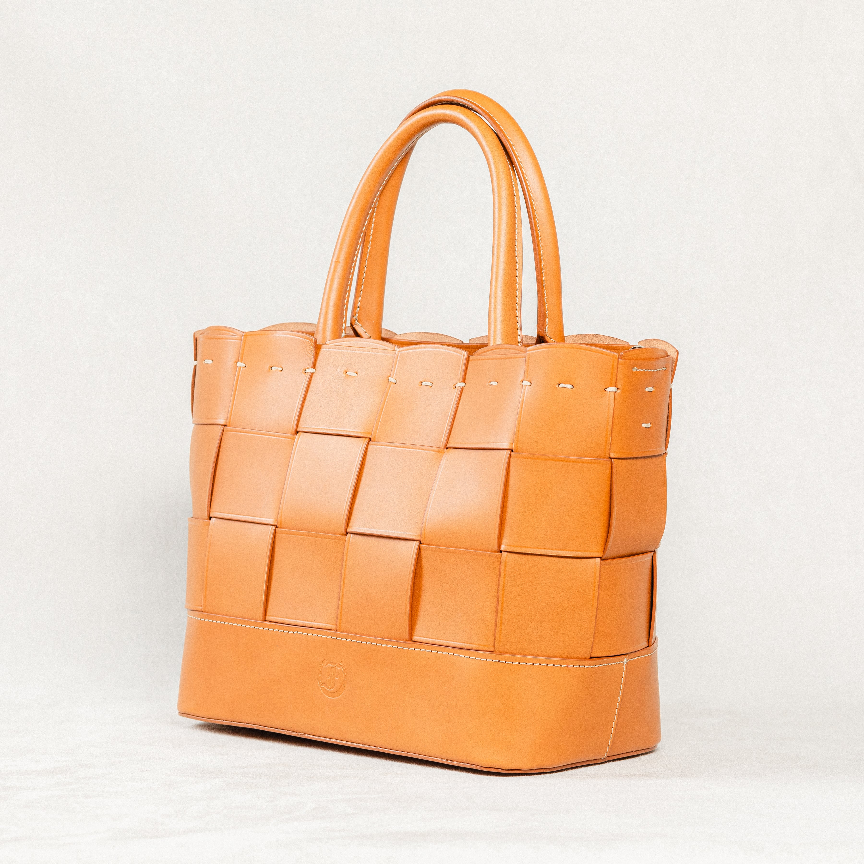 Cognac Manalos Bag by Freedman's, featuring a woven leather design and structured handles.