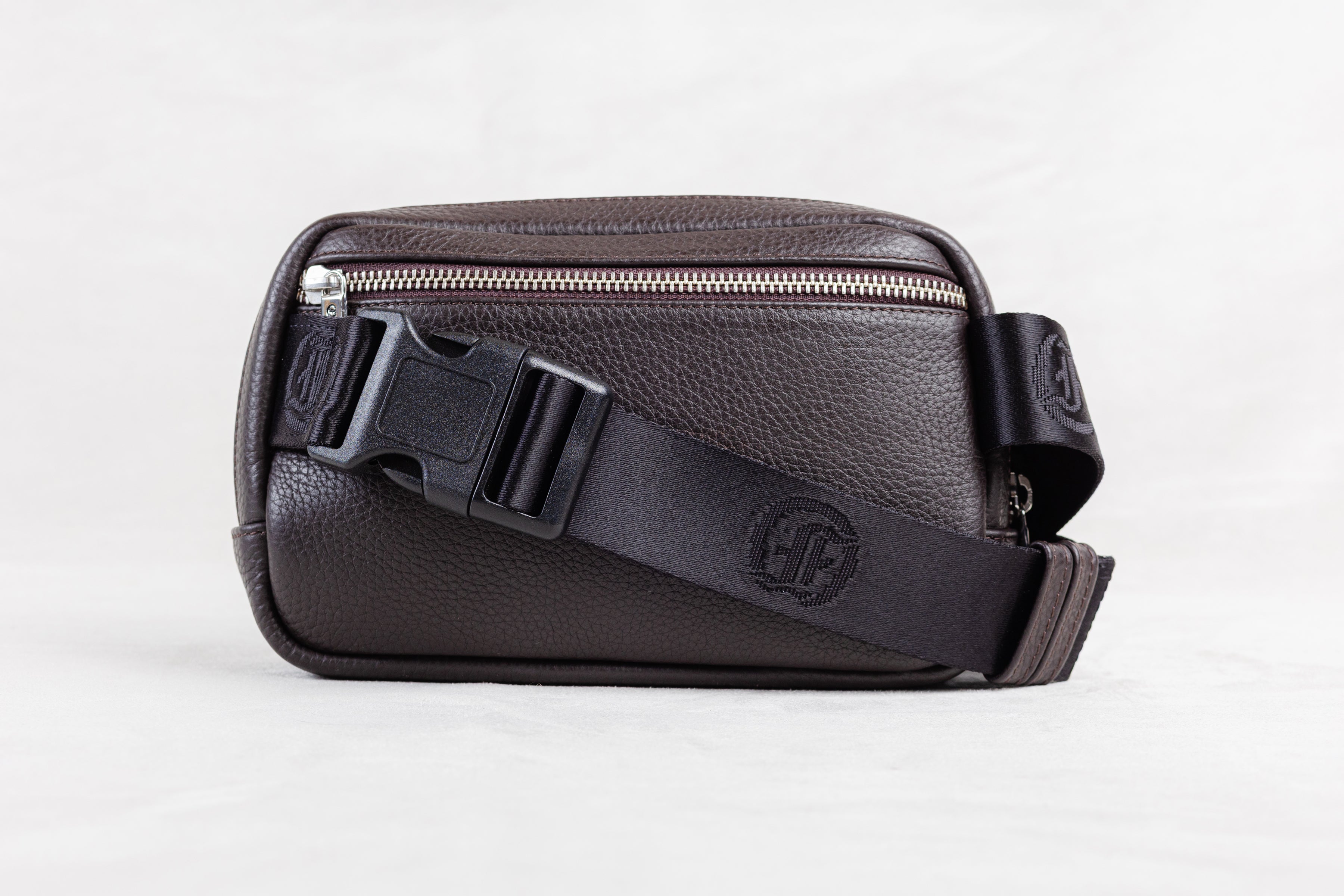 Brown leather crossbody or waist bag with a visible brand logo on white background
