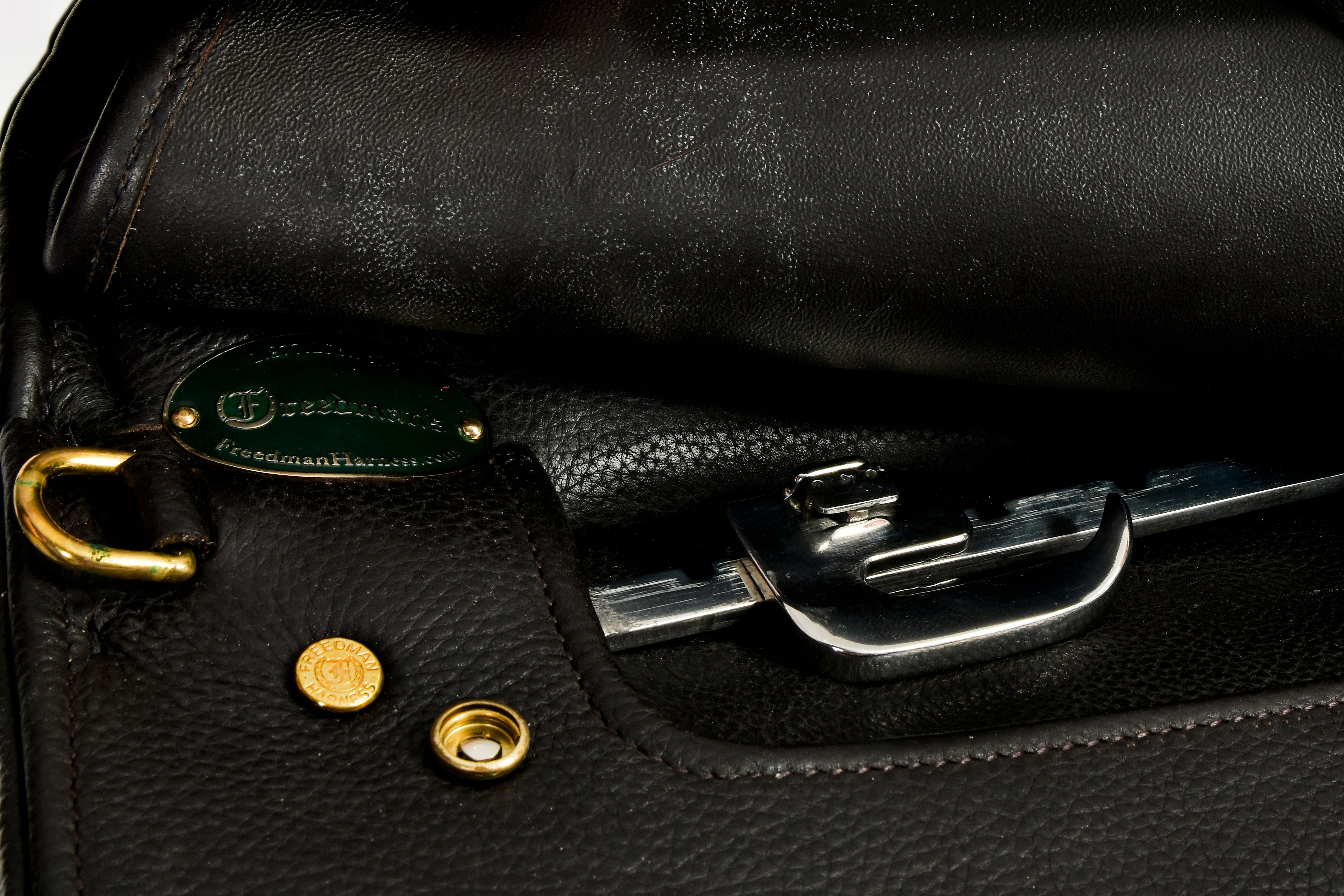 Close-up of the interior of a black leather Victory Pass HP Cutback Saddle, showcasing the gold ring, studs, and silver clasp hardware.