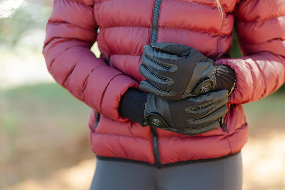 Close-up of Signature Ladies' II Winter Gloves in black, highlighting the reinforced finger panels, adjustable wrist straps, and knit cuffs while worn outdoors.