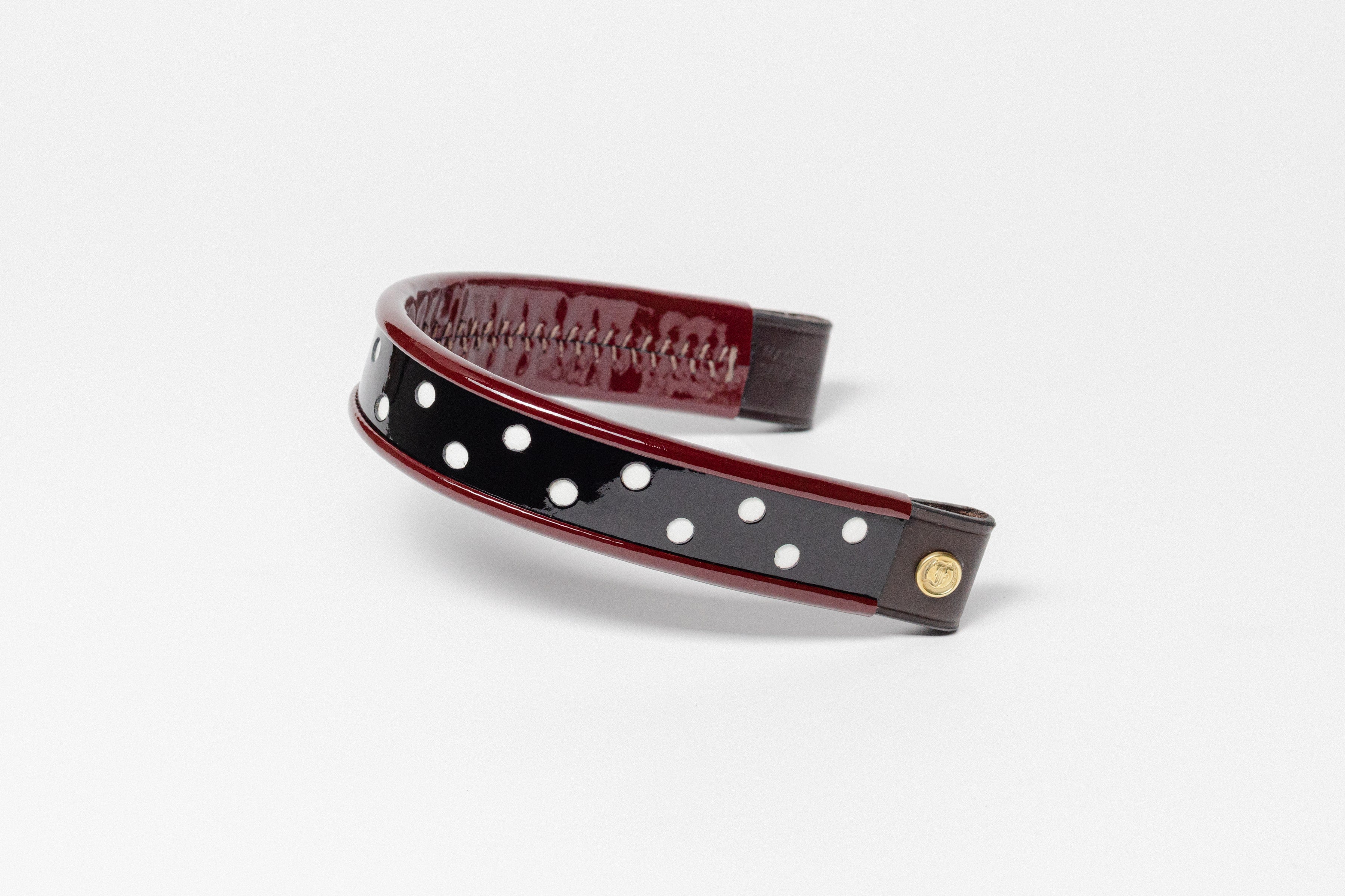 Curved turned edge browband, black patent leather, red dots, brown leather ends.