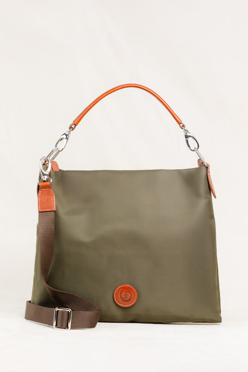 Freedman's Travois Bag in olive green, full view showing the bag's texture, brown leather accents, detachable shoulder and crossbody straps, and the brand's circular logo patch.