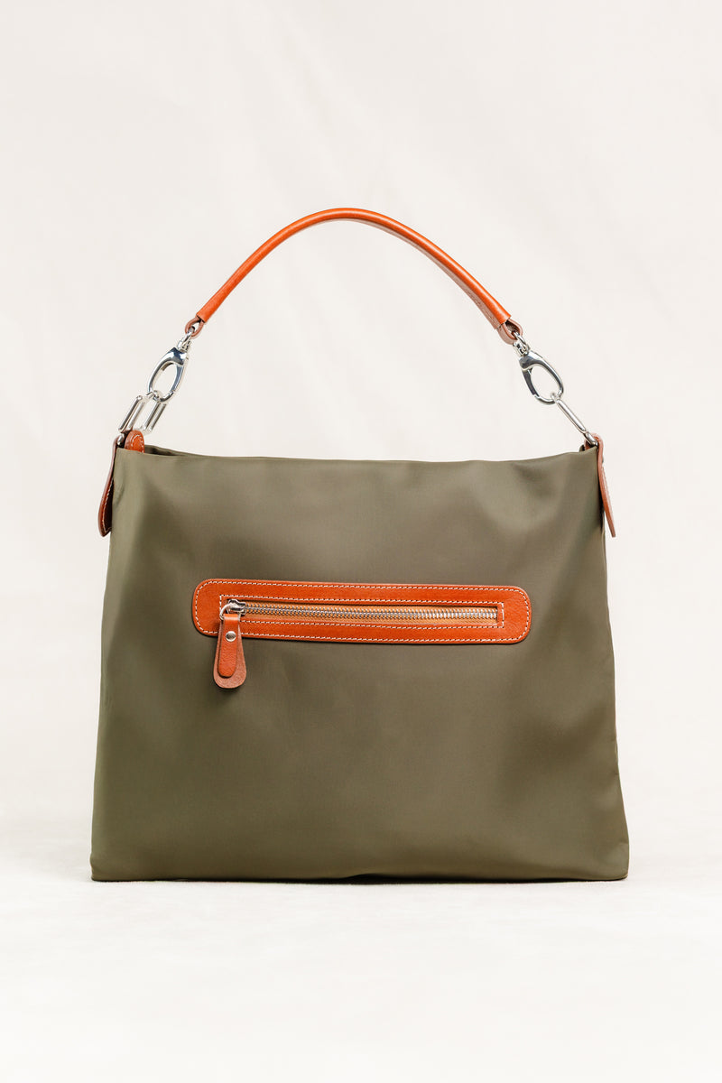 Travois Bag by Freedman's, close-up of the olive green shoulder bag showing the back zippered pocket with brown leather trim, a thin brown leather shoulder strap, and silver hardware.